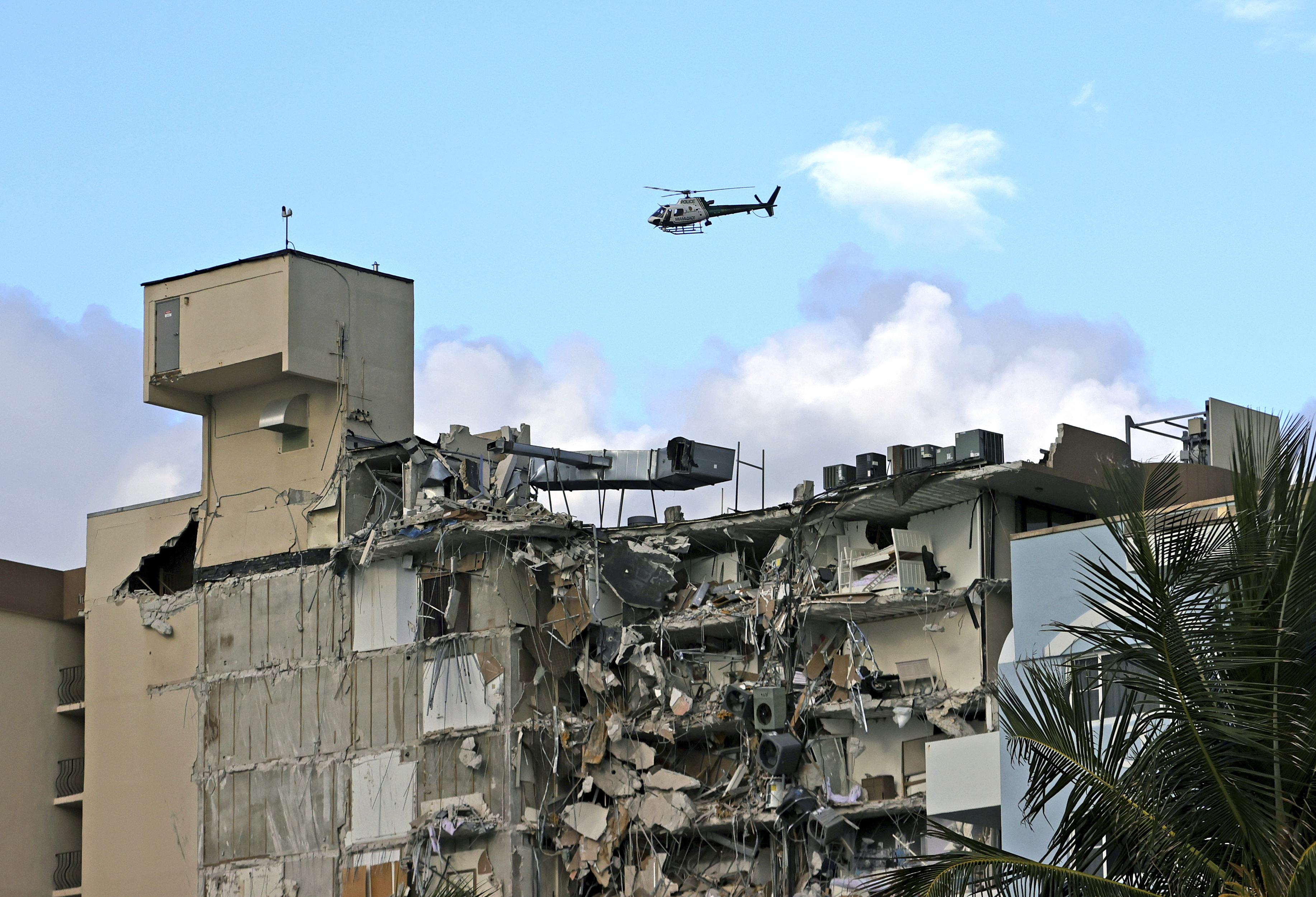 Un helicóptero de la Policía de Miami sobrevuela el condominio luego del derrumbe intentando divisar posibles atrapados. Foto: David Santiago/Miami Herald via AP