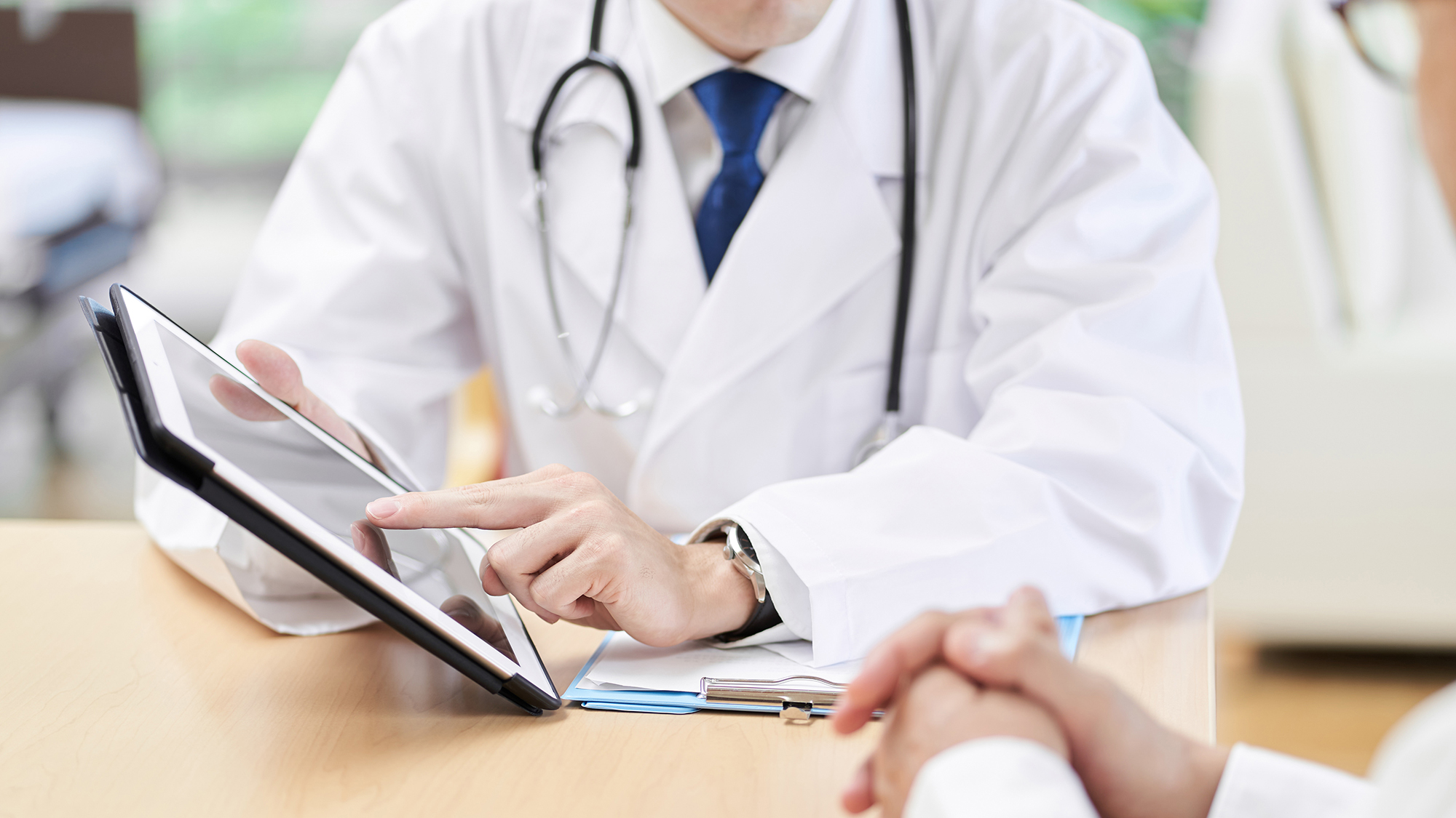 Manos de un médico varón explicando a los ancianos