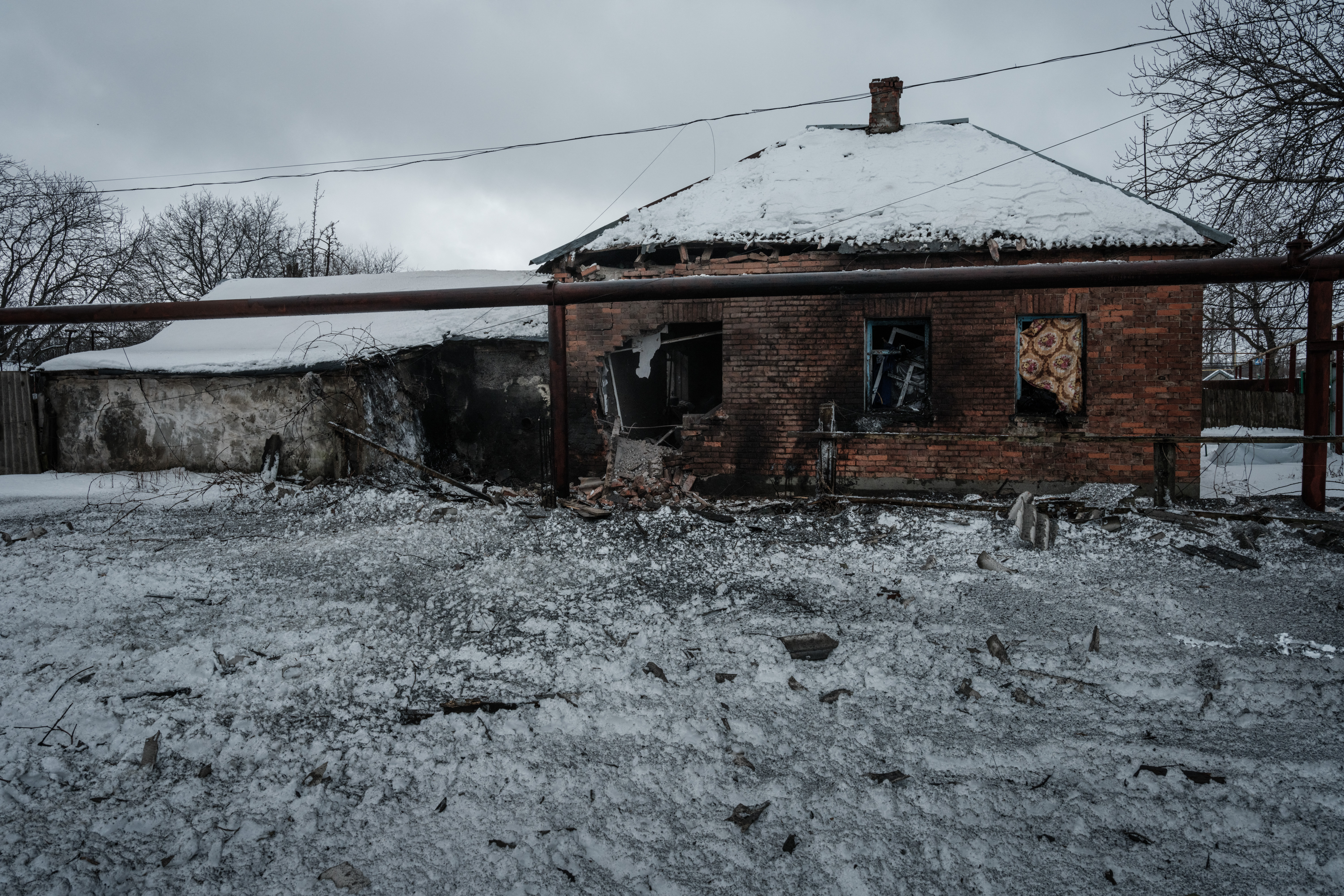 Una casa destruida por los bombardeos está cubierta de nieve en Chasiv Yar el 14 de febrero de 2023, en medio de la invasión rusa de Ucrania. (Foto de YASUYOSHI CHIBA / AFP)