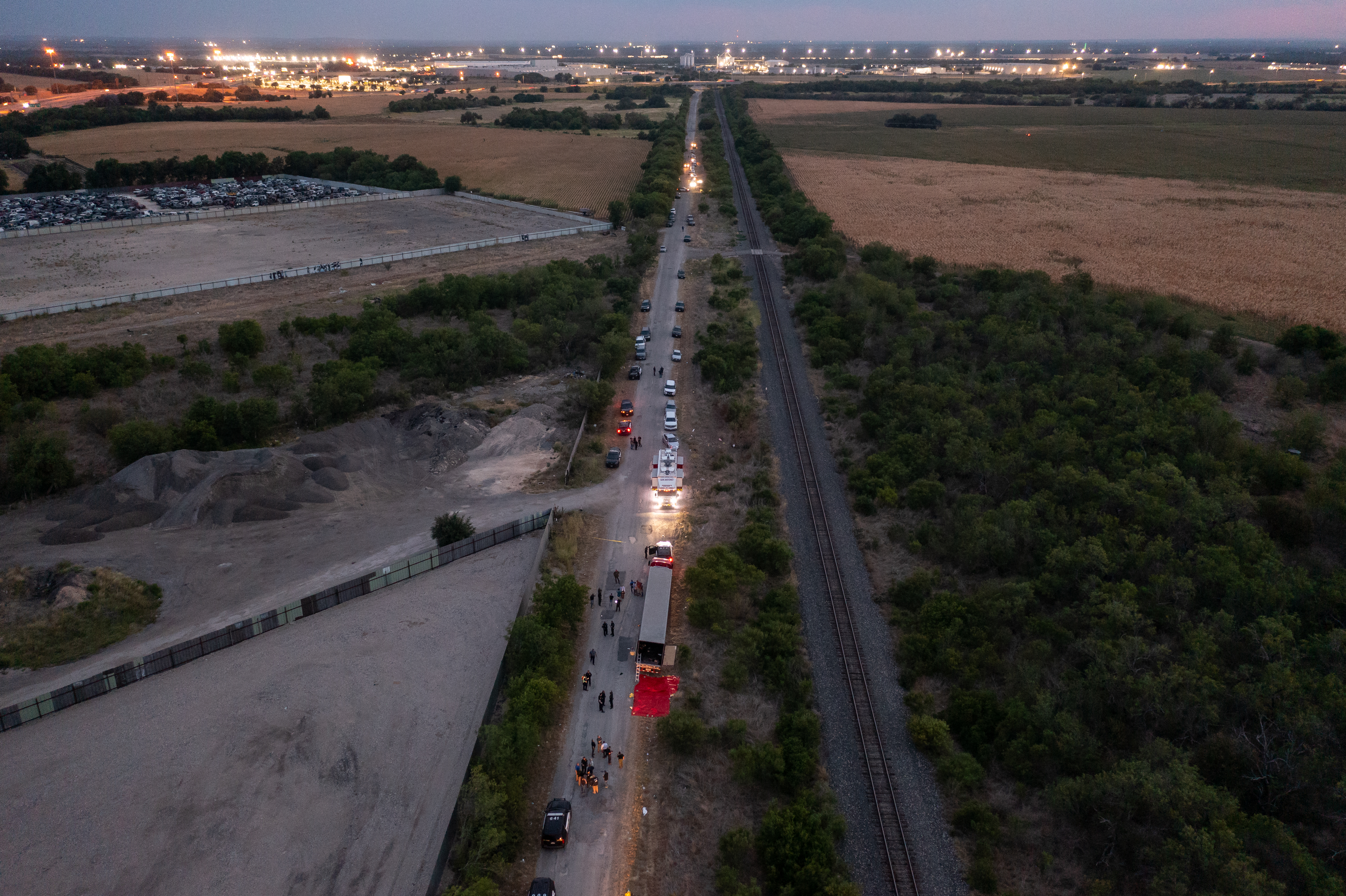 SAN ANTONIO, TX - JUNE 27: In this aerial view, members of law enforcement investigate a tractor trailer on June 27, 2022 in San Antonio, Texas. According to reports, at least 46 people, who are believed migrant workers from Mexico, were found dead in an abandoned tractor trailer. Over a dozen victims were found alive, suffering from heat stroke and taken to local hospitals.   Jordan Vonderhaar/Getty Images/AFP (Photo by Jordan Vonderhaar / GETTY IMAGES NORTH AMERICA / Getty Images via AFP)