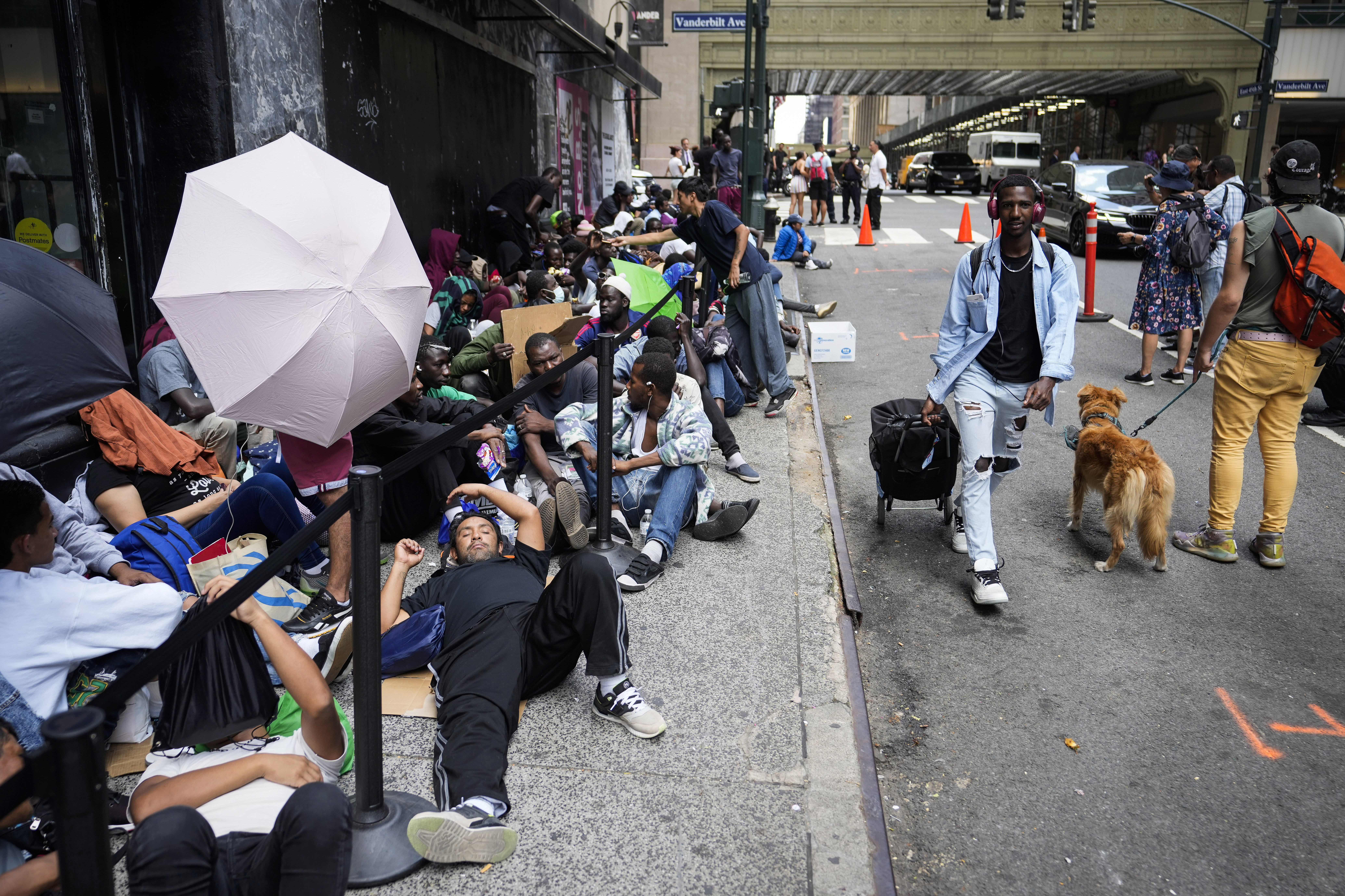 ARCHIVOS - Migrantes forman fila frente al  Roosevelt Hotel que la ciudad de Nueva York emplea como alojamiento temporario, 31 de julio de 2023. (AP Foto/John Minchillo, File)