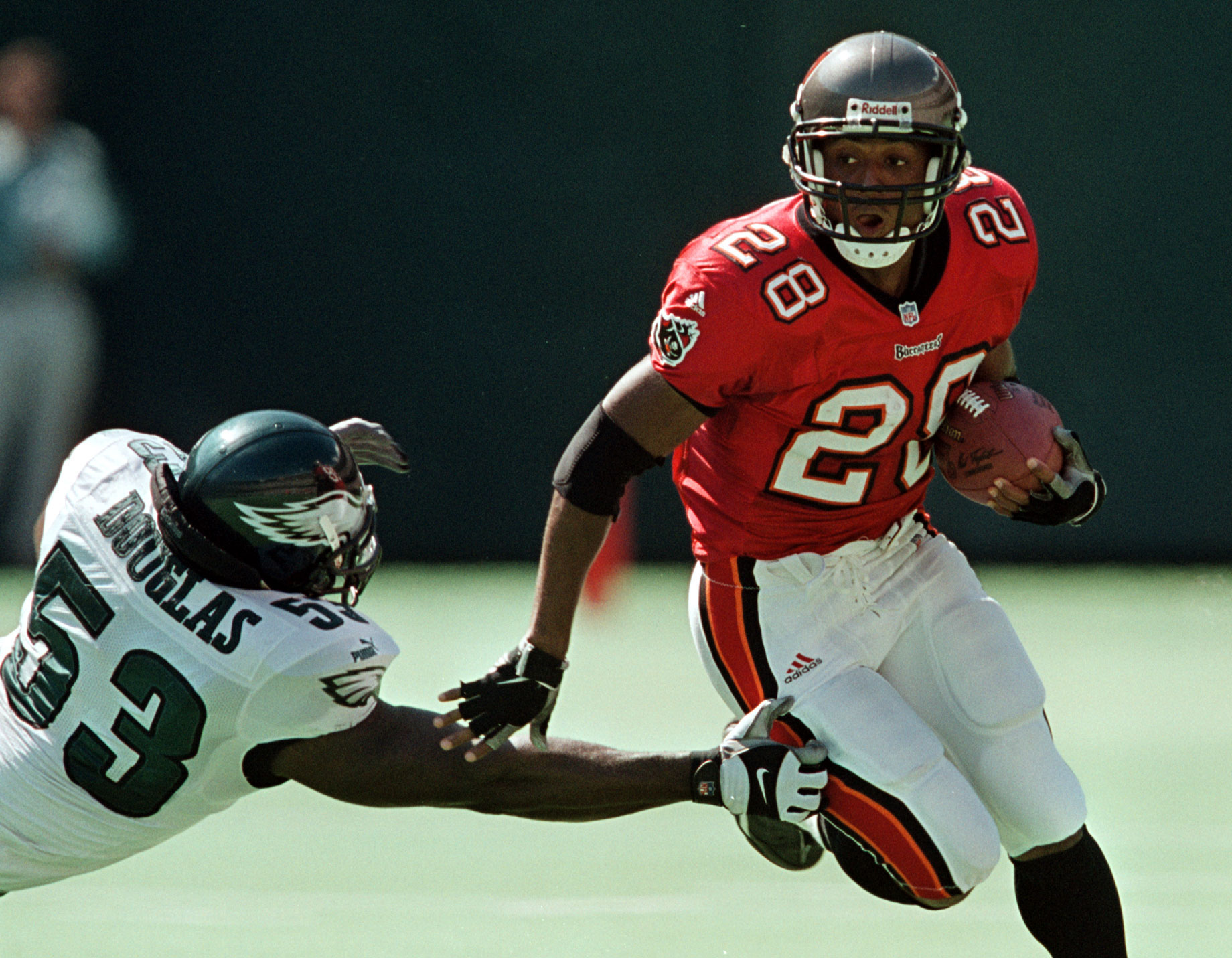 Warrick Dunn of the Atlanta Falcons runs with the ball while pursued