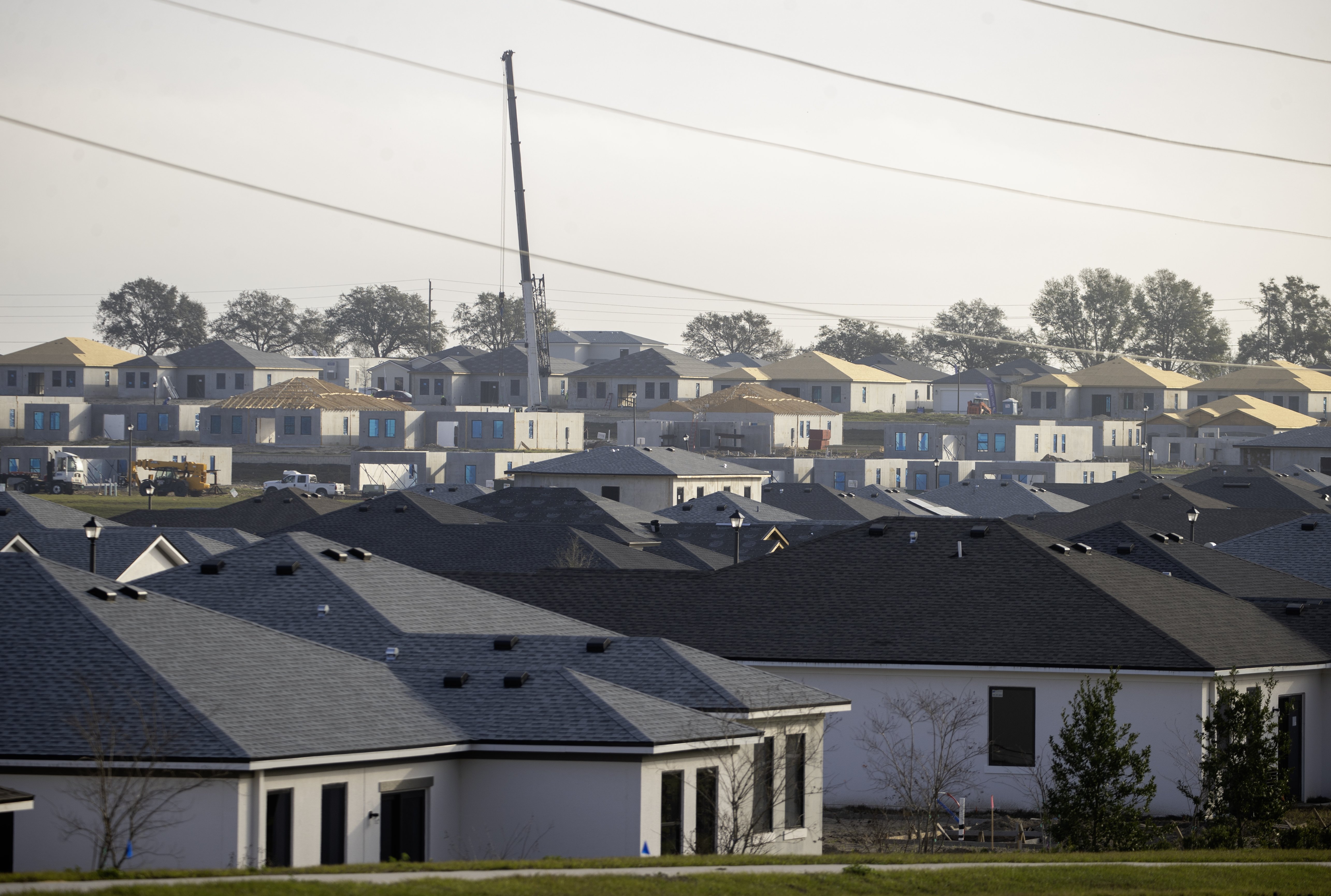 A crane rises above a development in Lake County. For decades, contractors have replaced natural land with concrete and buildings that shed rain, producing millions of pounds of runoff pollution that flows to ailing waterways.
