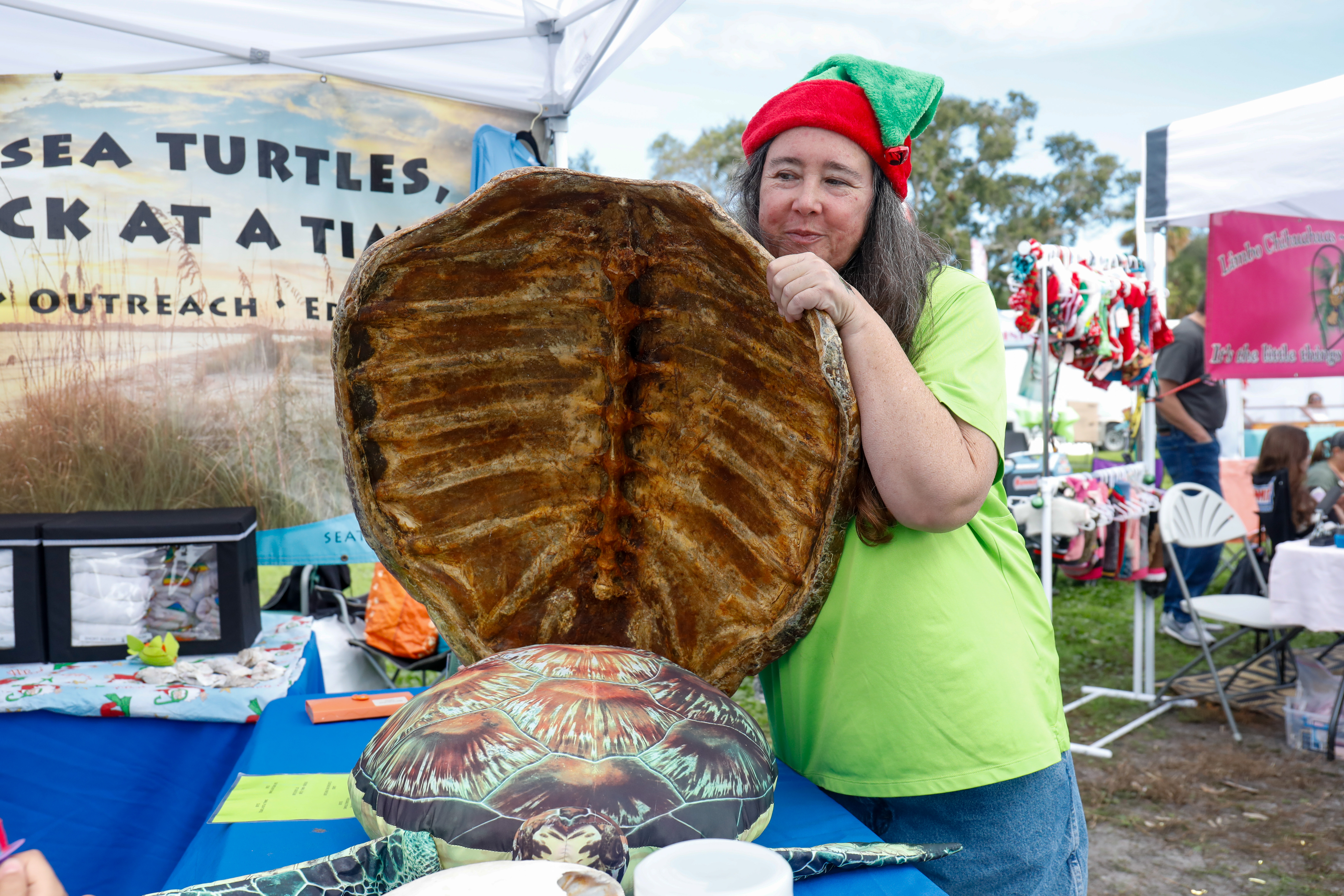Theresa Arenholz, Sea Turtle Trackers director, shows off a sea turtle shell to shoppers at Shopapalooza.