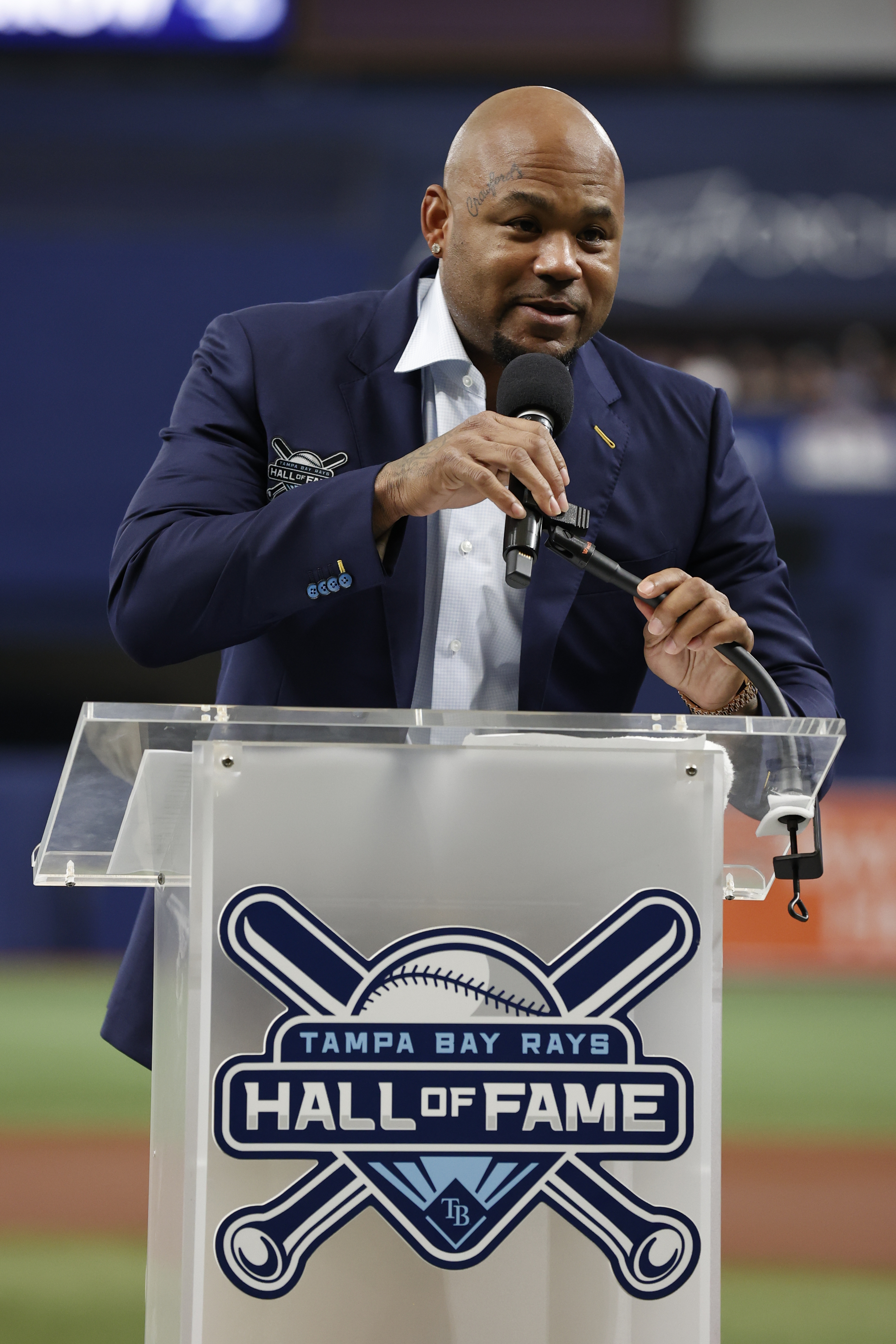 Former Tampa Bay Rays player Carl Crawford, center, embraces his son  Justin, front right, after throwing out a ceremonial first pitch during his  Rays Hall of Fame induction ceremony prior to a