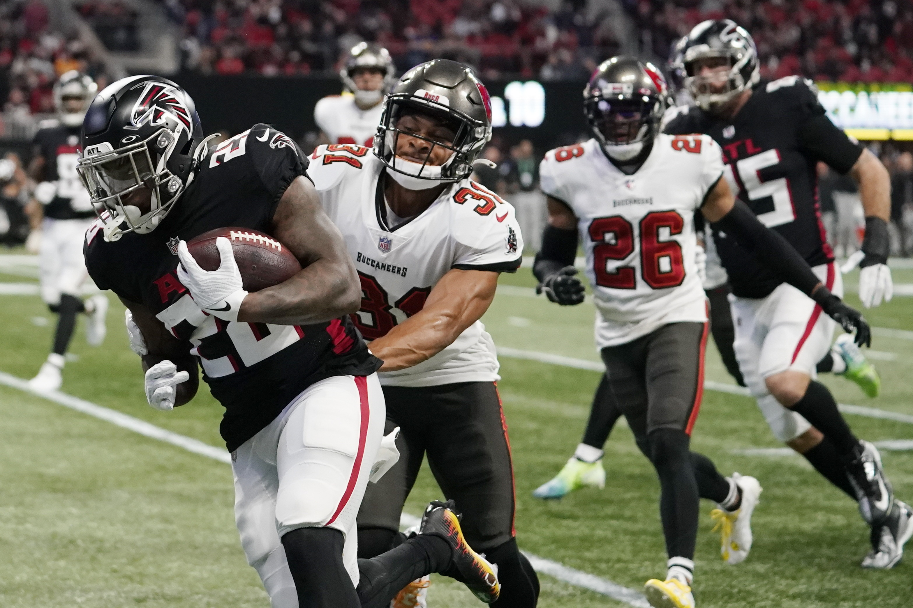 Mike Davis of the Atlanta Falcons is tackled by Antoine Winfield