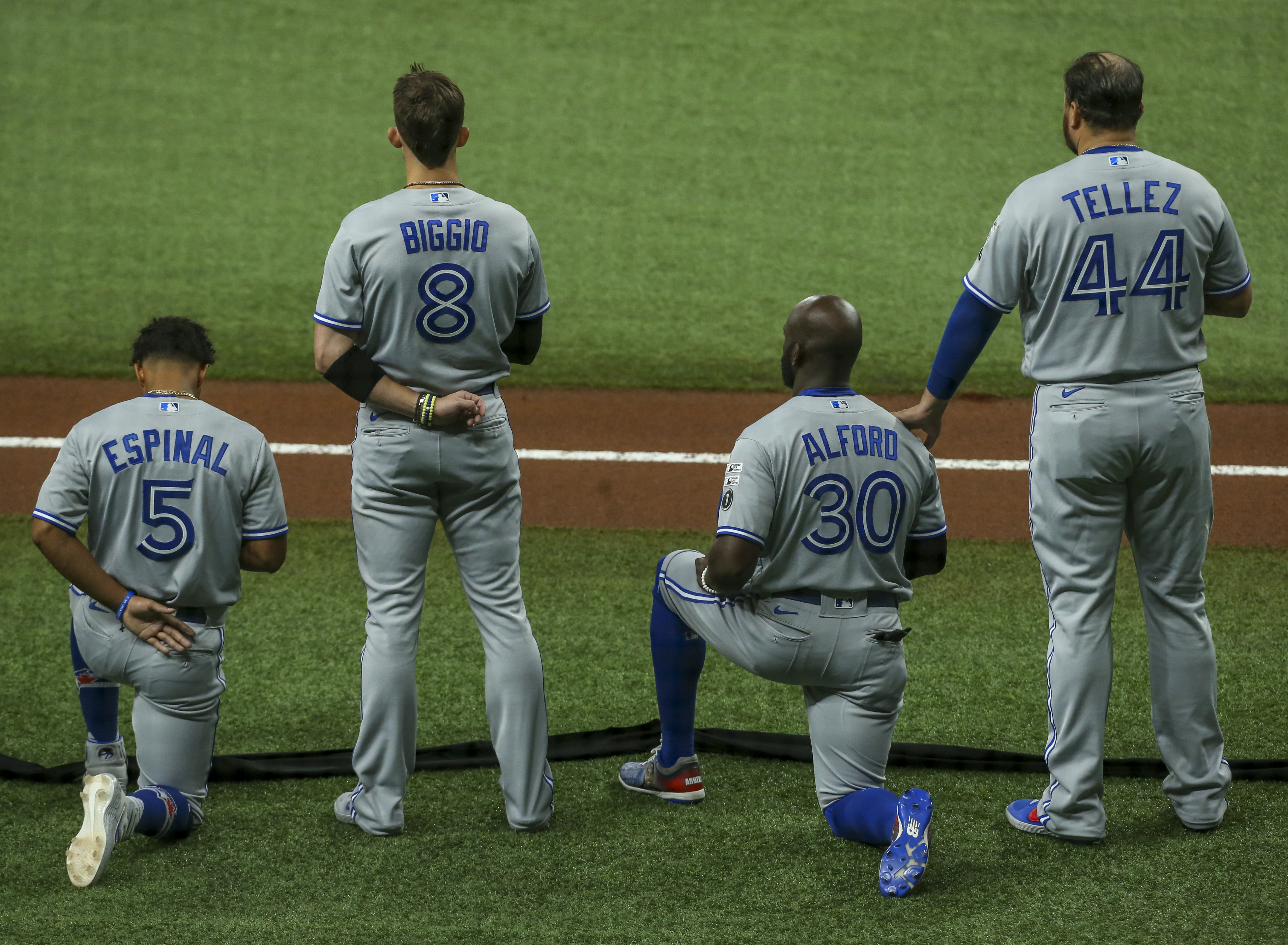 Members of the Blue Jays put their hats back on after the national anthem  during the opening da …