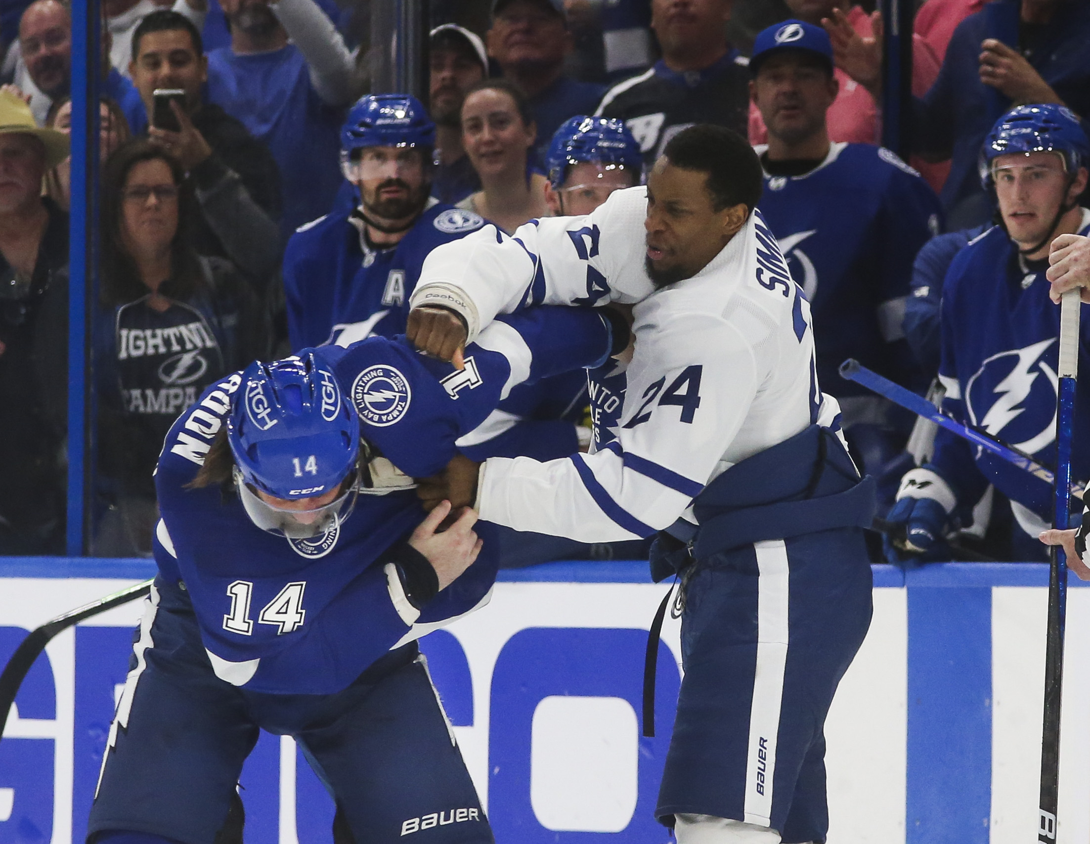 Officials separate Toronto Maple Leafs forward Wayne Simmonds (24) and  Tampa Bay Lightning forward Corey Perry, right, as they fight during the  third period of Game 1 of an NHL hockey Stanley