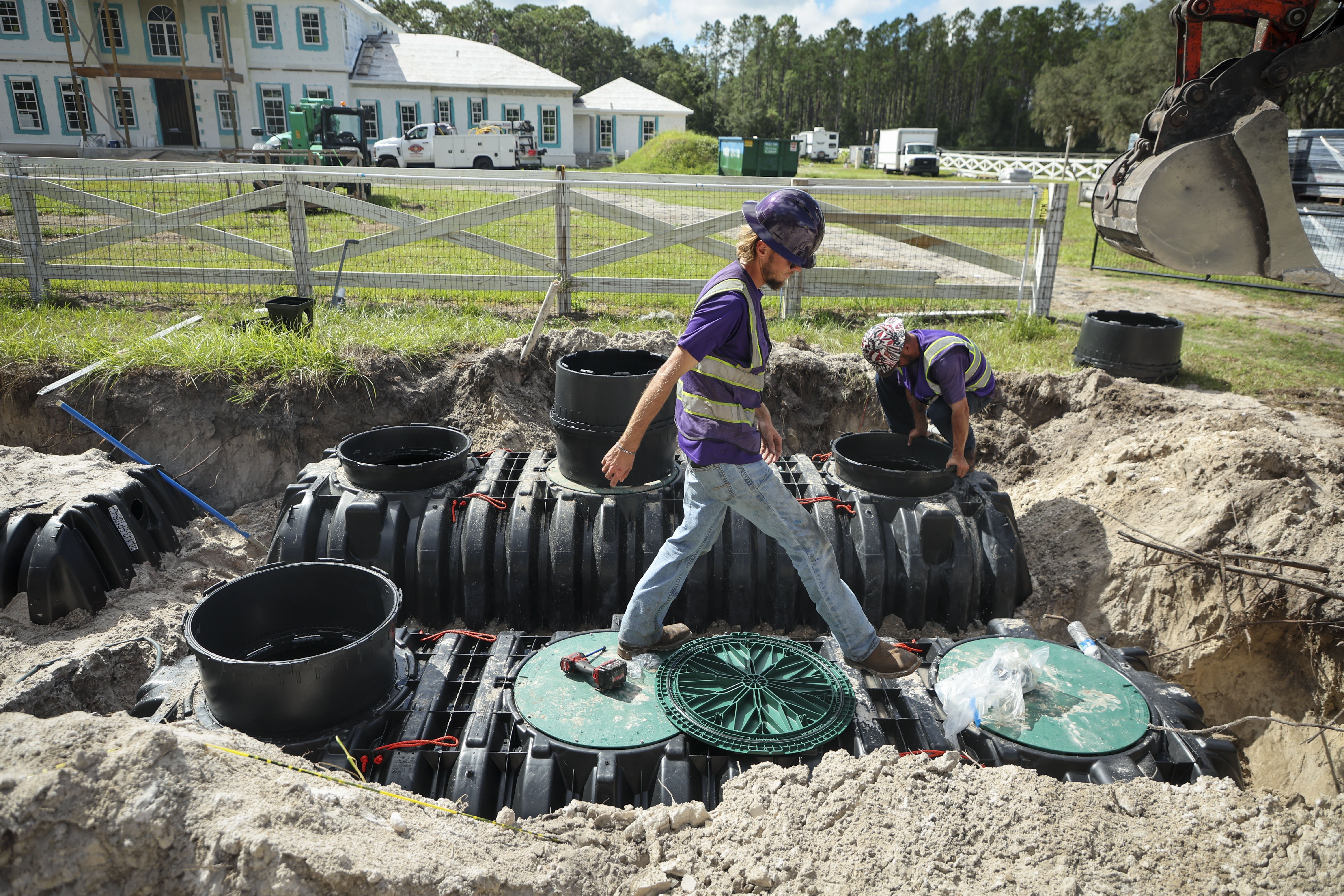 Clayton Trainer, left, and Austin Utter, with Ace Septic & Waste, work in Odessa on the installation of a septic system with an aerobic treatment unit that adds oxygen to support greater chemical reductions. Regulators have started requiring enhanced septic tanks in certain areas around contaminated waterways. Older tanks remove less nitrogen and are a significant source of pollution.