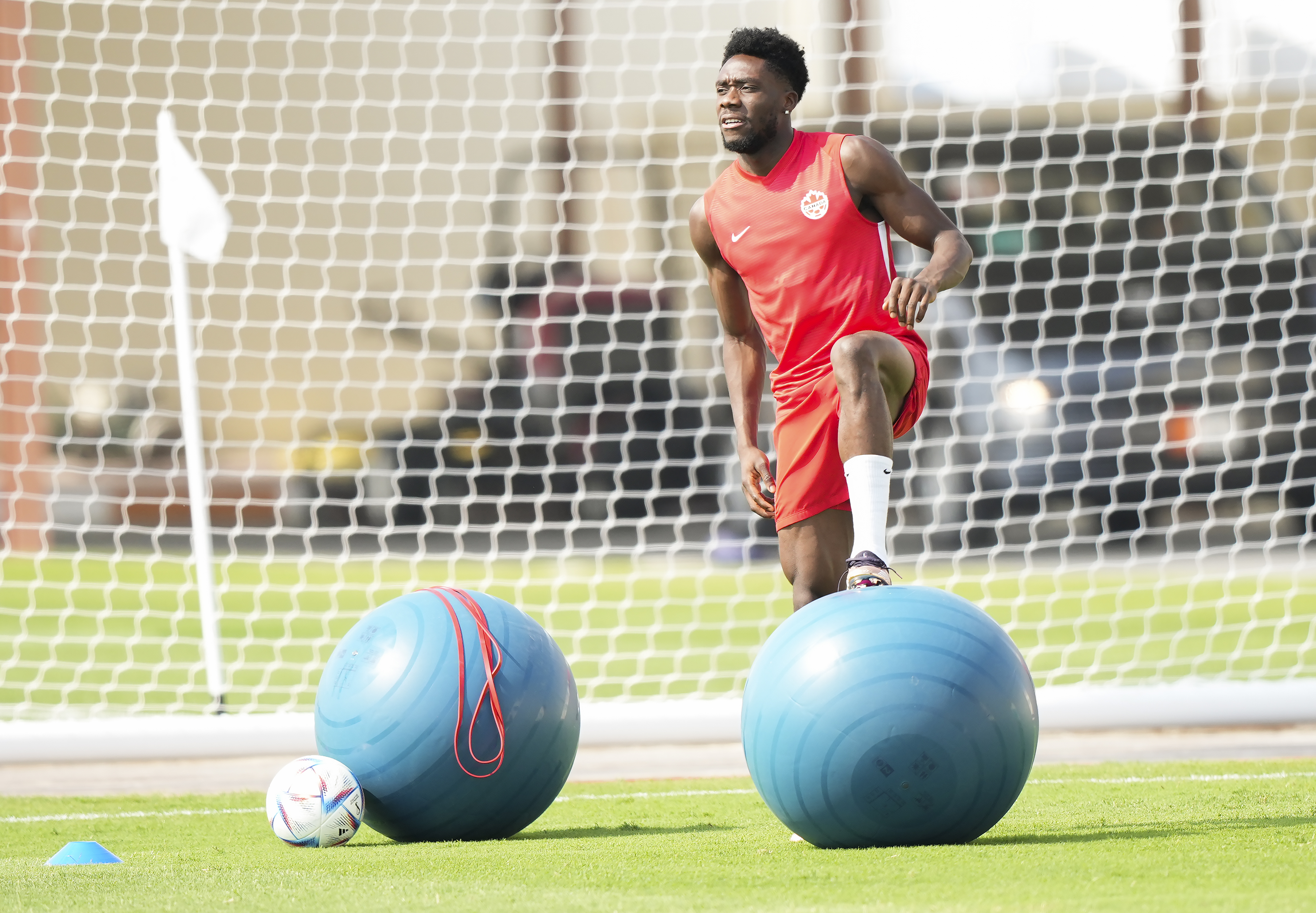 Canada forward Alphonso Davies (19) falls to the turf after he