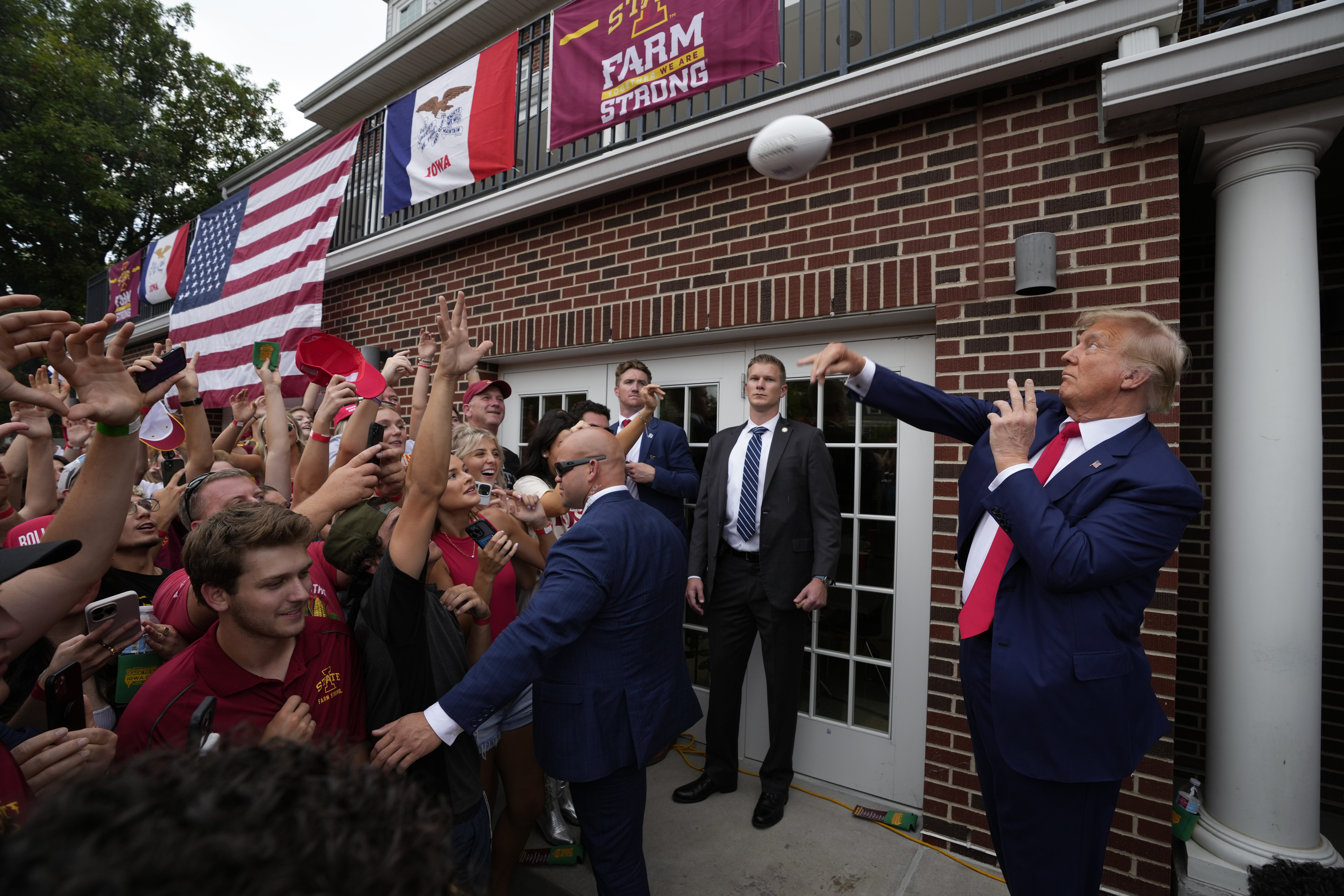 Trump stops at a fraternity house on his way to Iowa-Iowa State football game, outdrawing his rivals pic