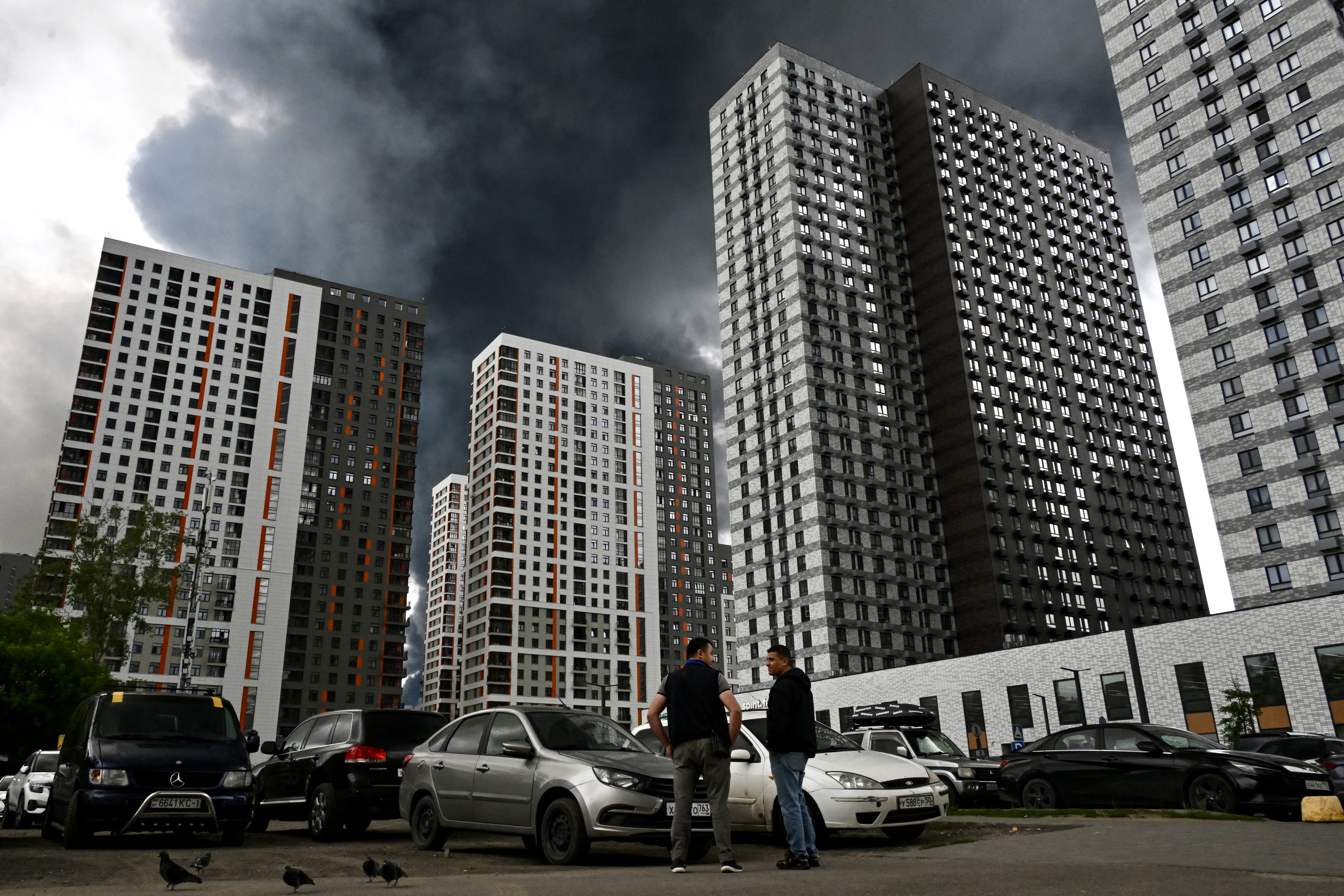 People talk Thursday in a Moscow residential area blanketed with smoke following Ukrainian drone attacks. (AFP/Getty Images)