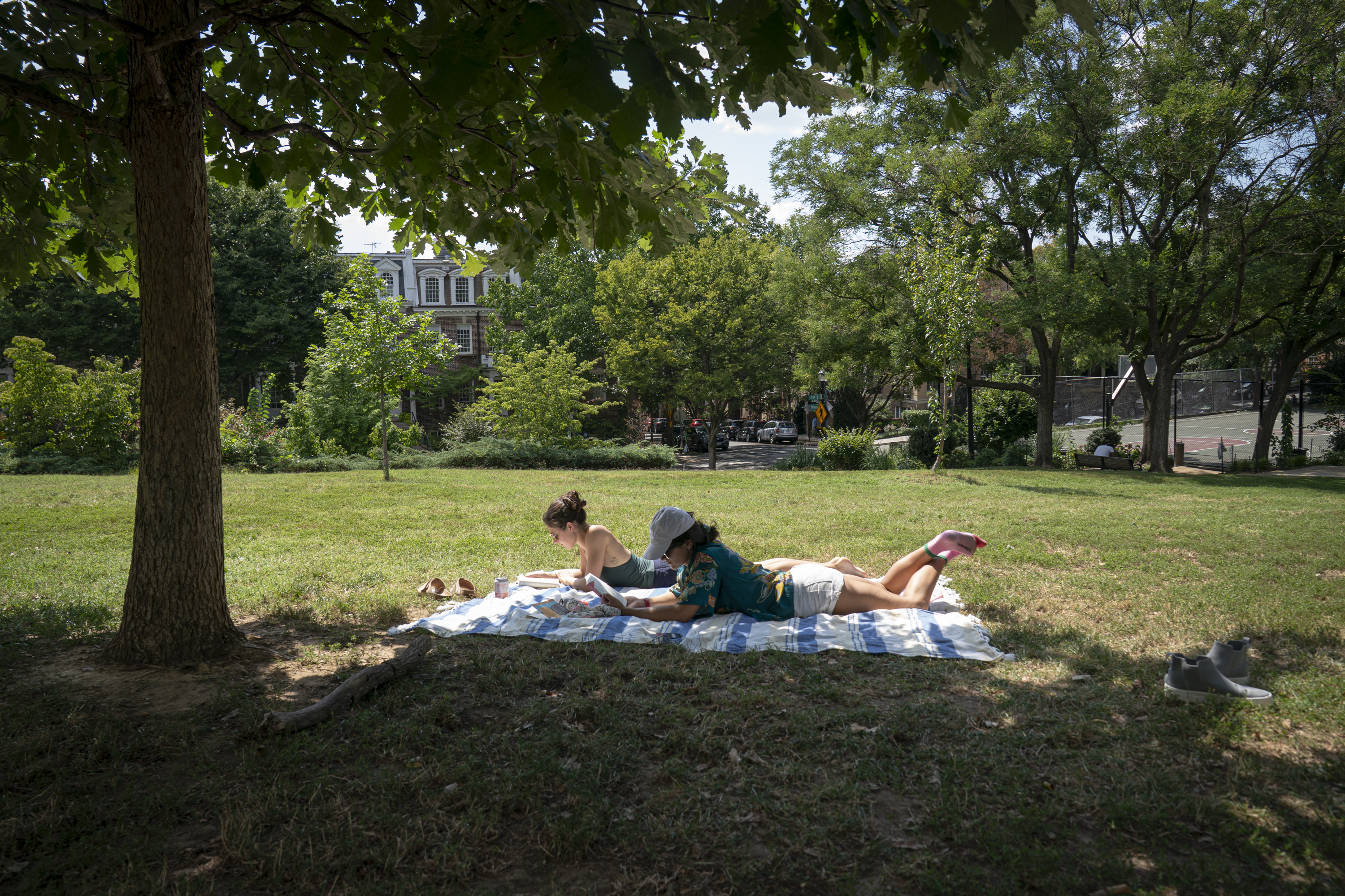 Ecisi Beach, left, and Angela Troiain take a reading break in Kalorama Park. (Maxine Wallace/The Washington Post)