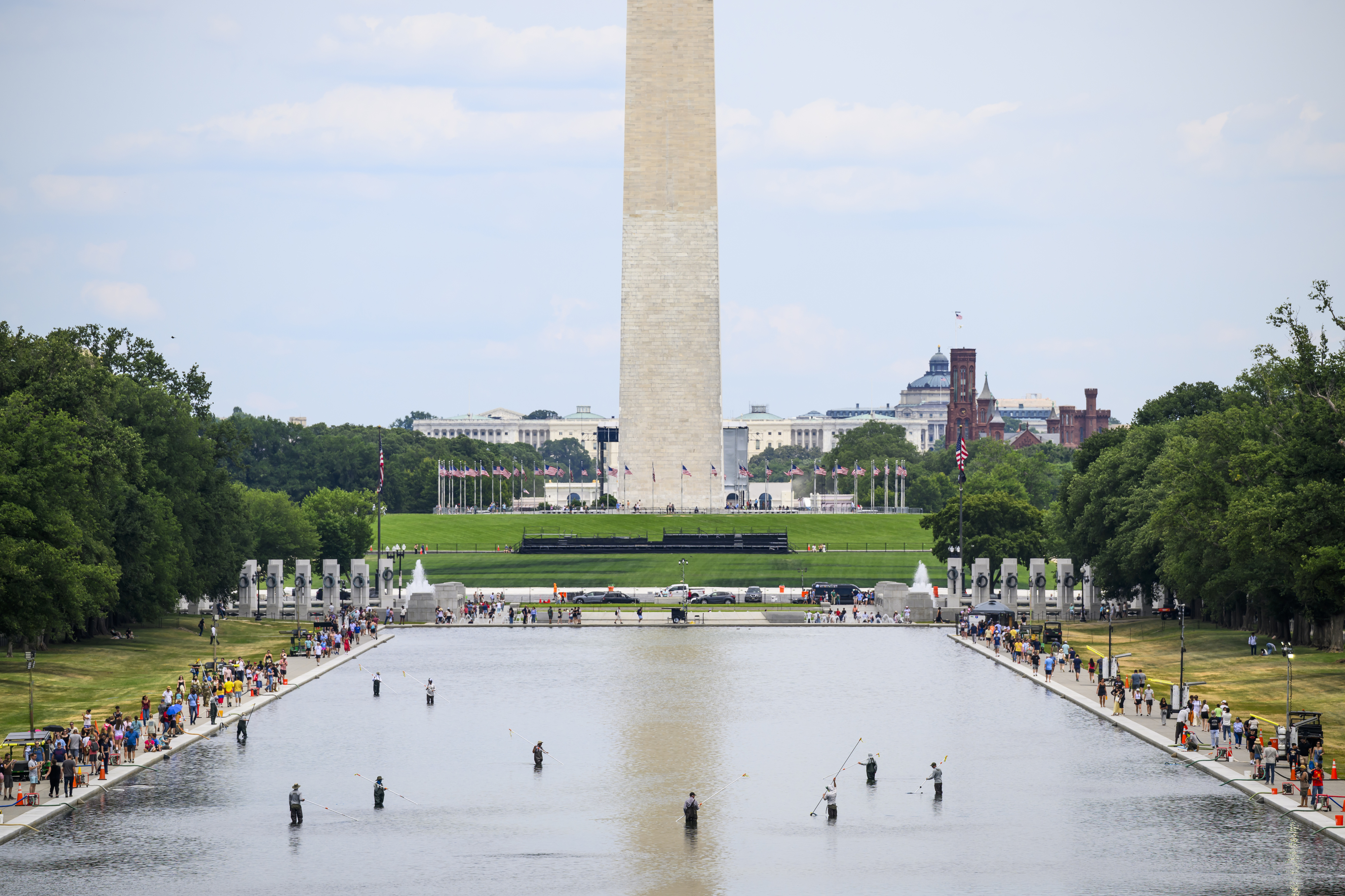 Park Service personnel work on removing algae from the Reflecting Pool on Sunday. (Pete Kiehart/For The Washington Post)