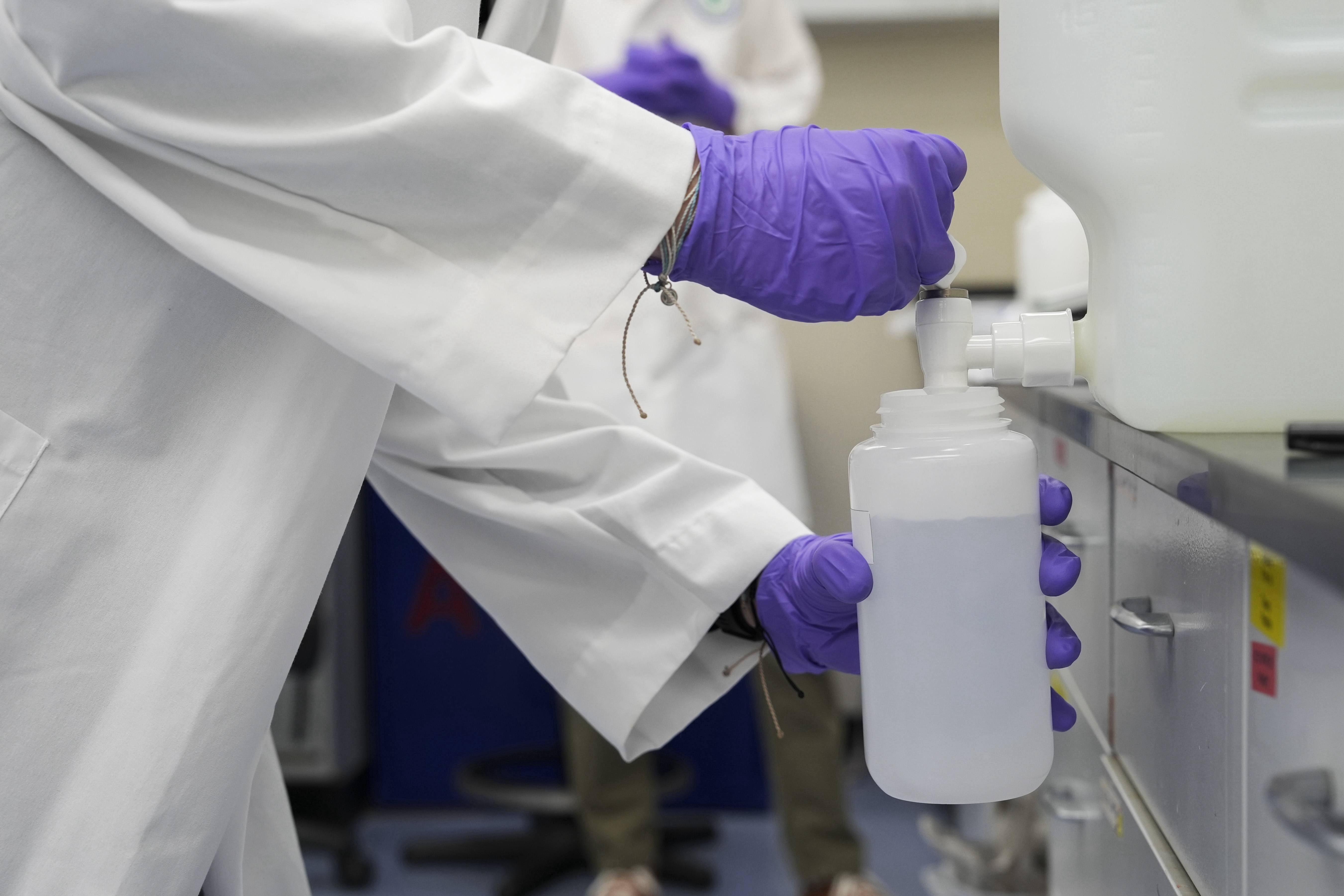 Water samples with “forever chemicals” are poured into a container for research at an Environmental Protection Agency lab in Cincinnati. (Joshua A. Bickel/AP)