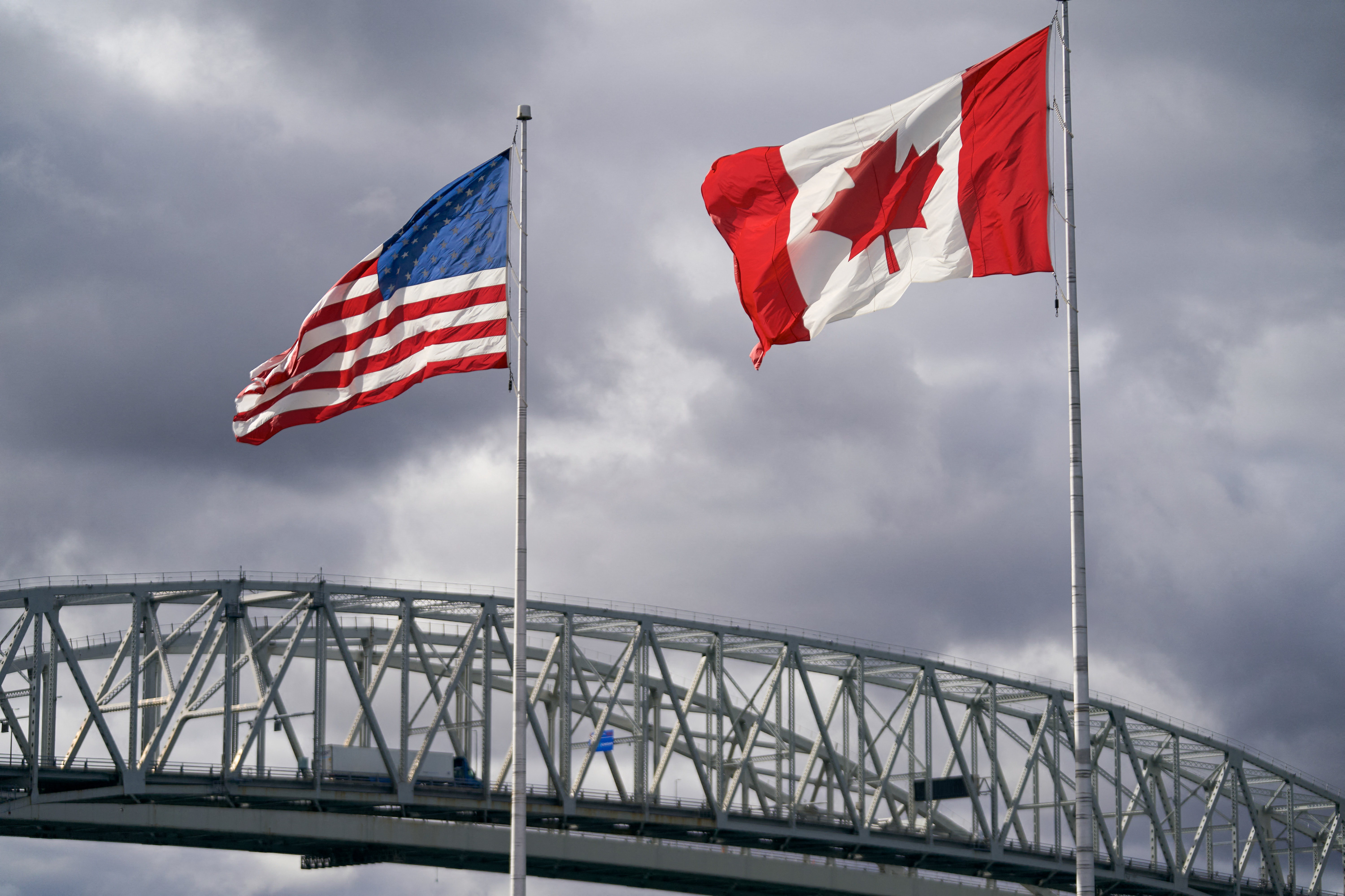 U.S. and Canadian flags next to the Blue Water Bridge border crossing in Point Edward, Ontario. (Geoff Robins/AFP/Getty Images)