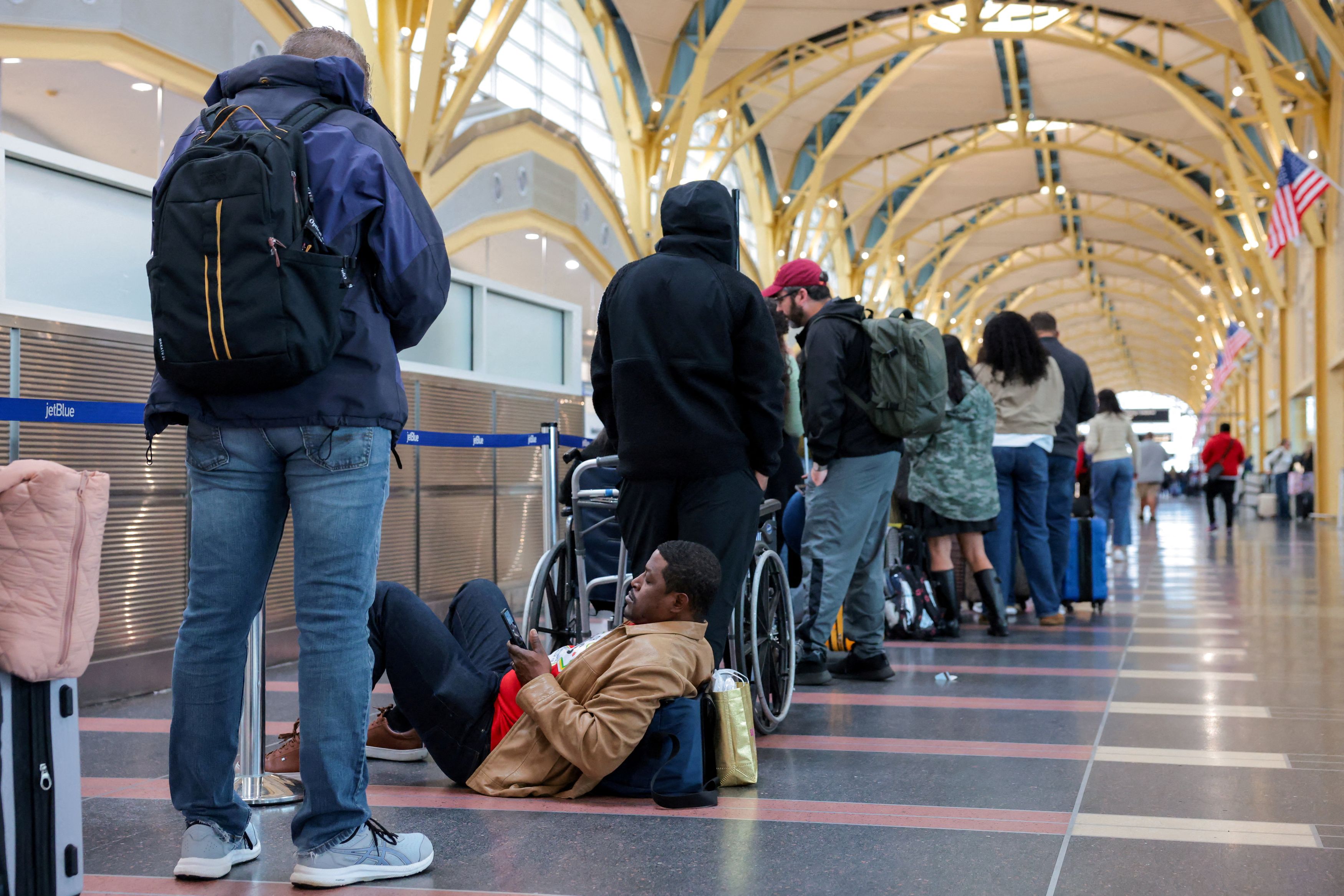 Passengers wait in a check-in line at Reagan National Airport in Arlington, Virginia, on March 16. (Kylie Cooper/Reuters)