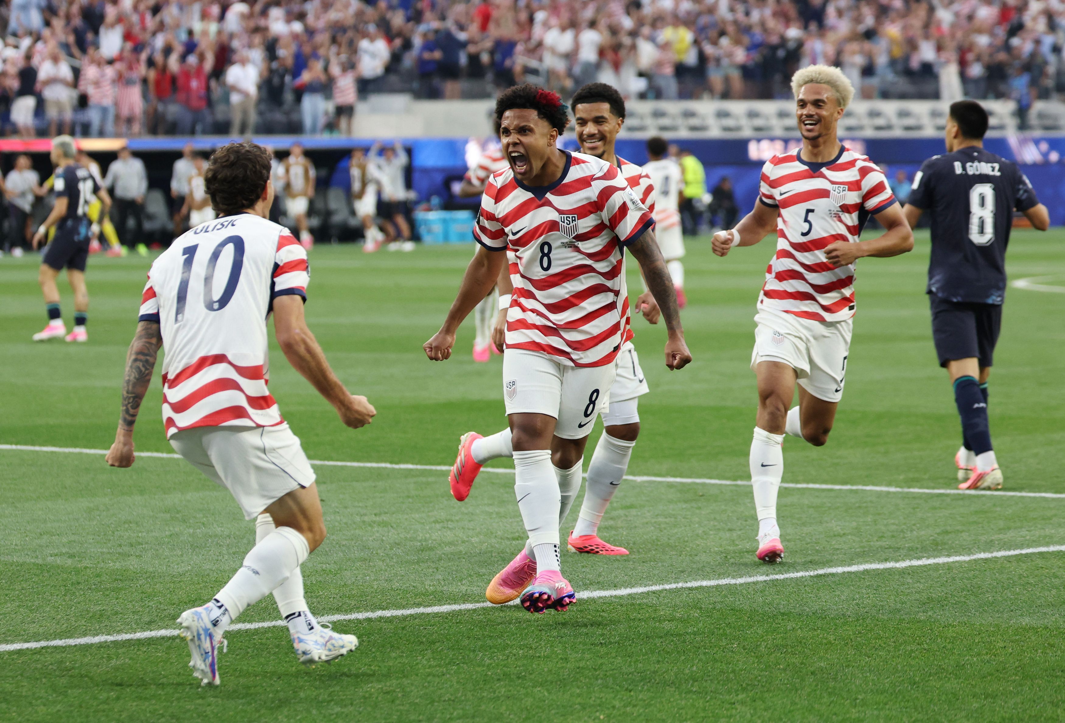 Weston McKennie and Christian Pulisic celebrate the first goal against Paraguay in the Group D opening match June 12. (Mario Anzuoni/Reuters)