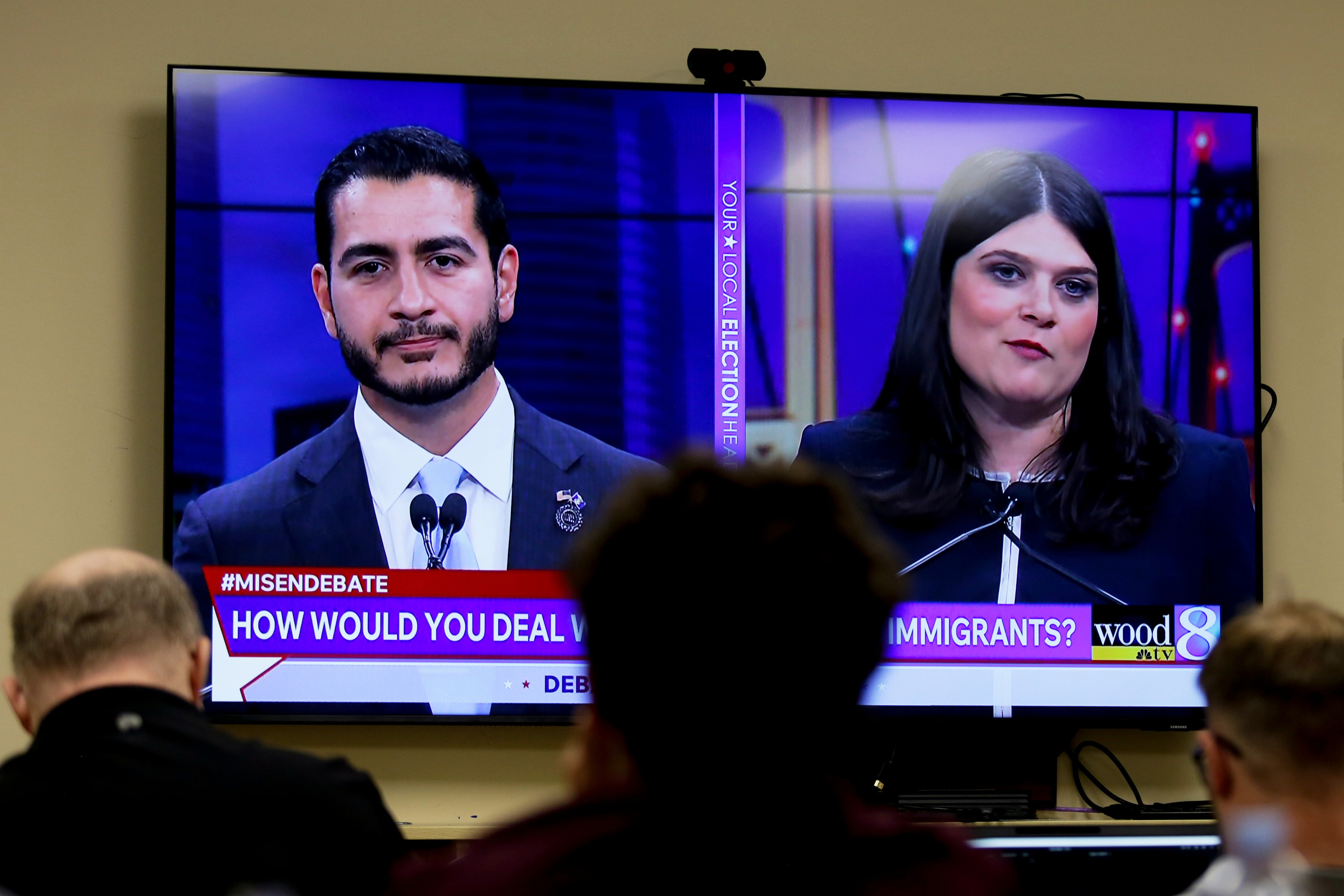 U.S. Senate candidates Abdul El-Sayed, left, and Rep. Haley Stevens (D-Michigan) appear on a television inside the spin room at WOOD-TV studios in Grand Rapids, Michigan, during their debate on Tuesday. (Kristen Norman/AP)