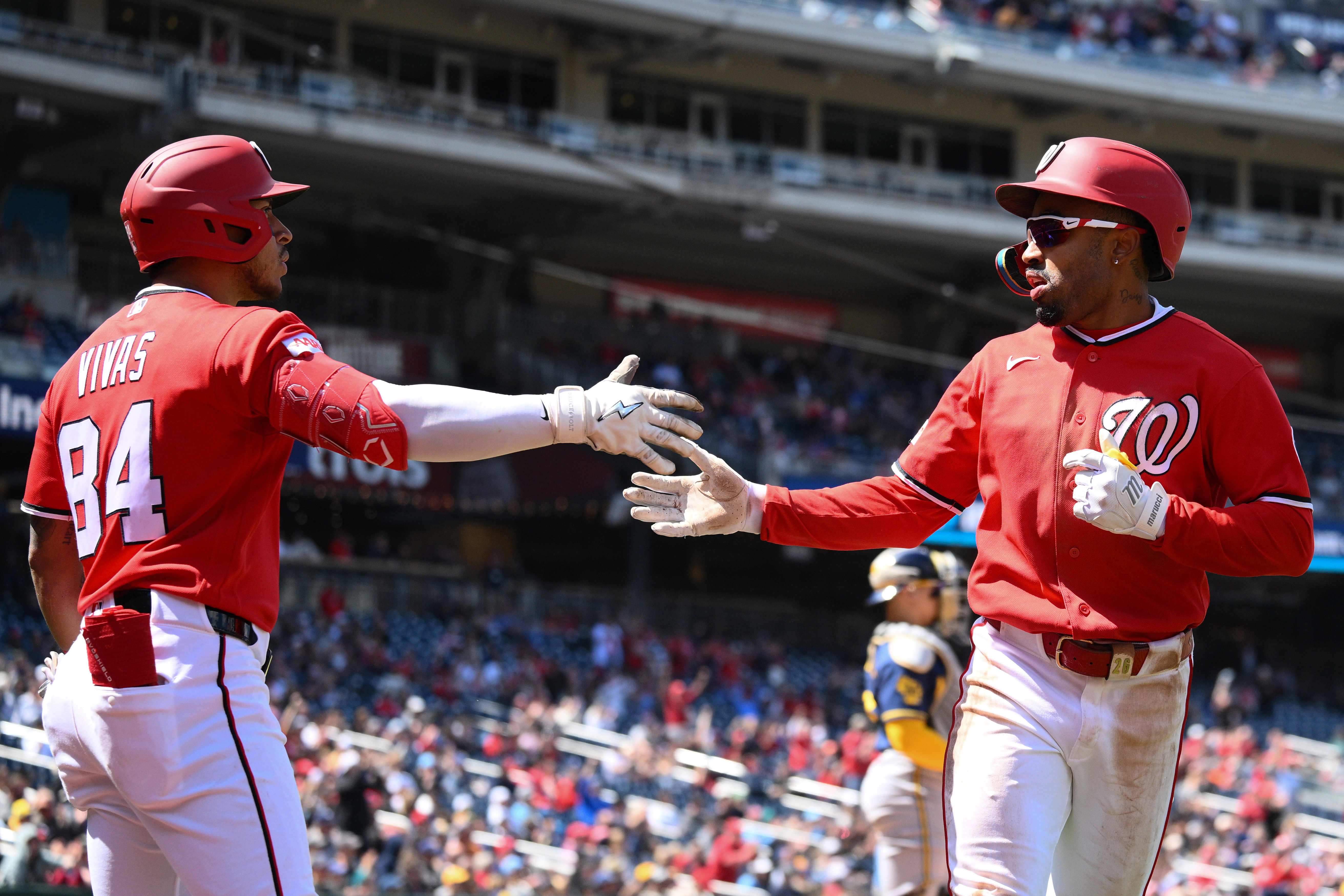 The Nationals' Nasim Nuñez, right, is greeted by Jorbit Vivas after scoring on a fifth-inning triple by José Tena on Sunday at Nationals Park. (Nick Wass/AP)