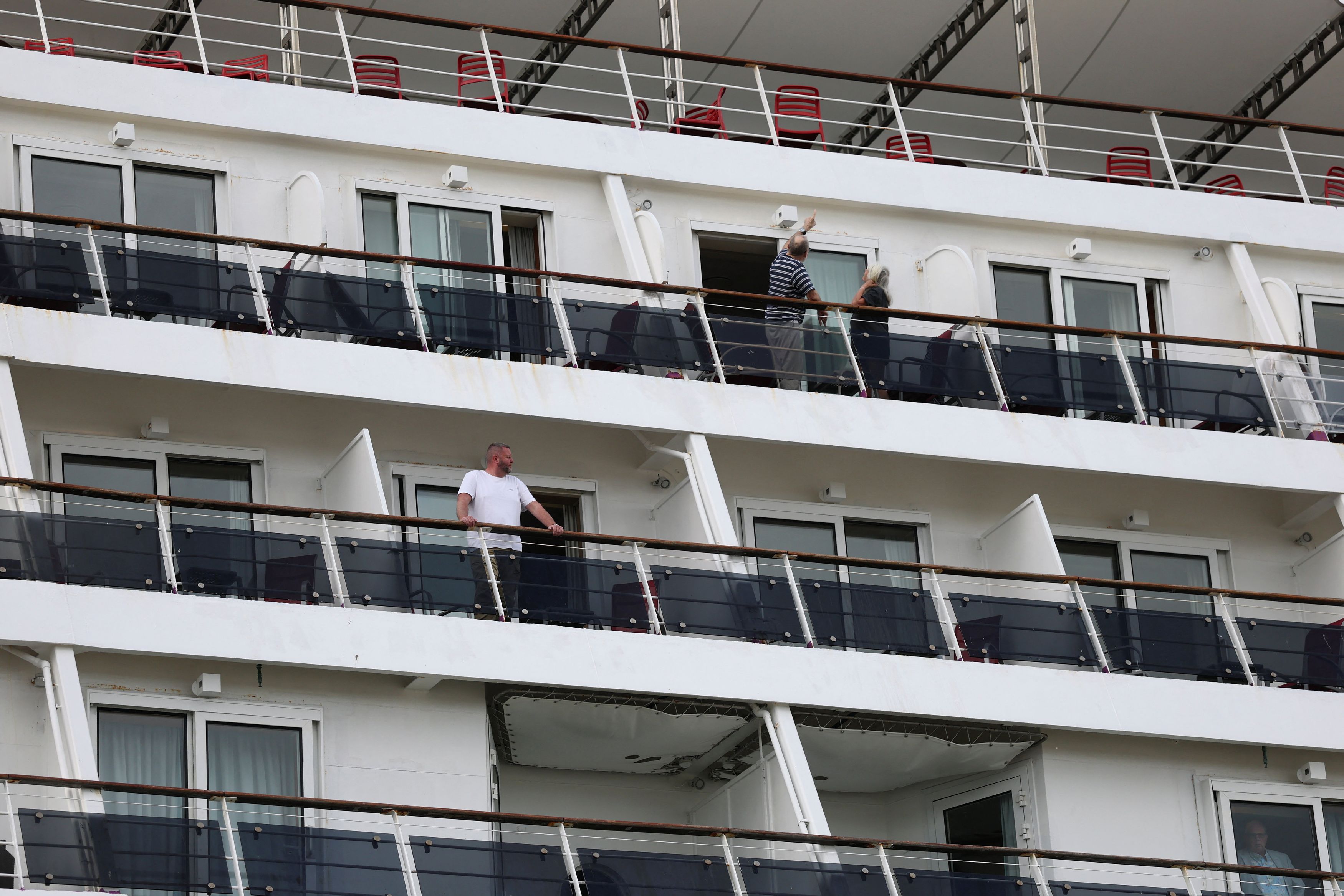 Passengers stand on board the cruise ship Ambition, operated by the Ambassador Cruise Line, after local authorities said passengers could not disembark following an outbreak of possible gastroenteritis reported on board, in Bordeaux, France, on May 13. (Stephane Mahe/Reuters)