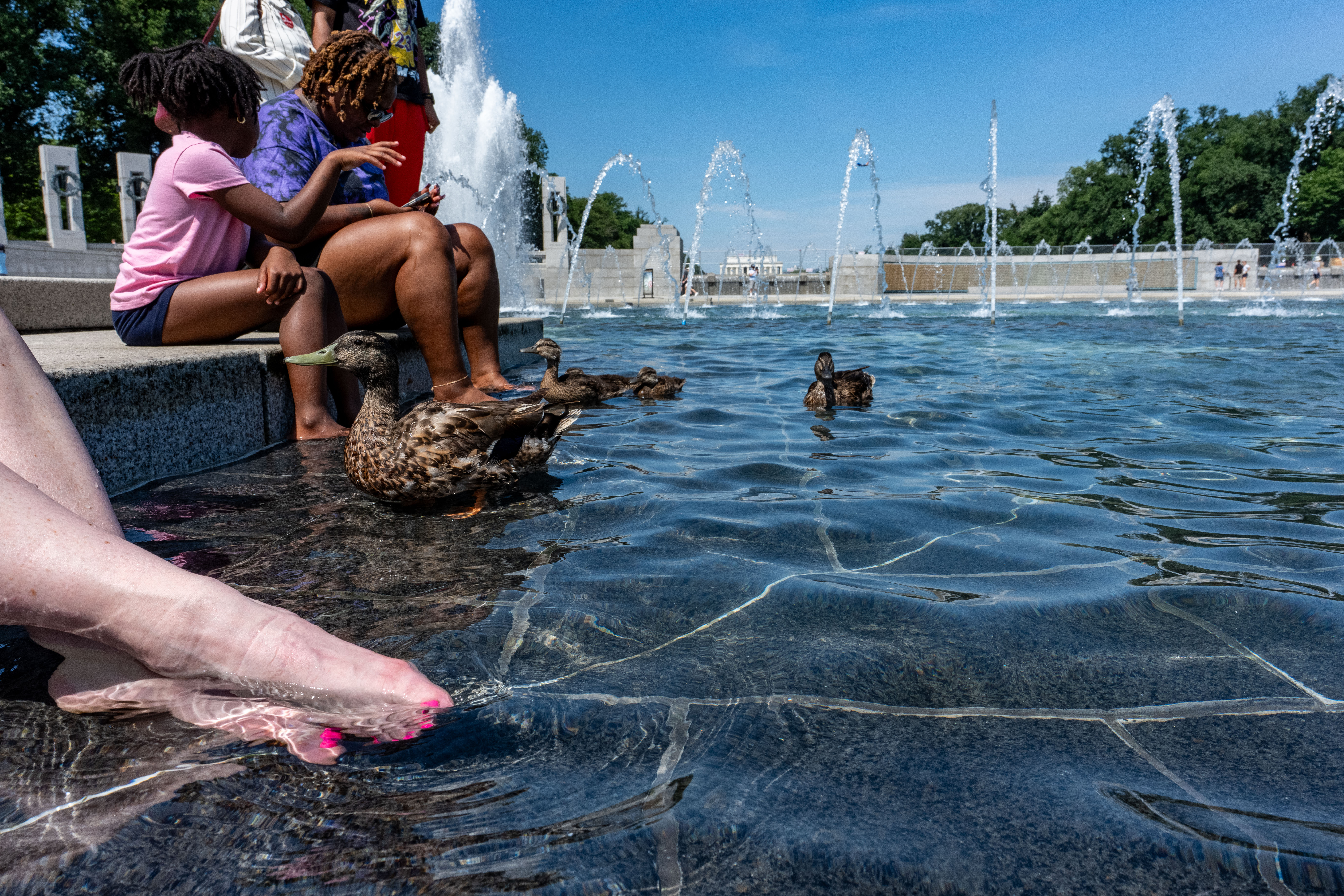 Visitors cool their feet in the fountain at the National World War II Memorial on Tuesday. (Alex Brandon/AP)