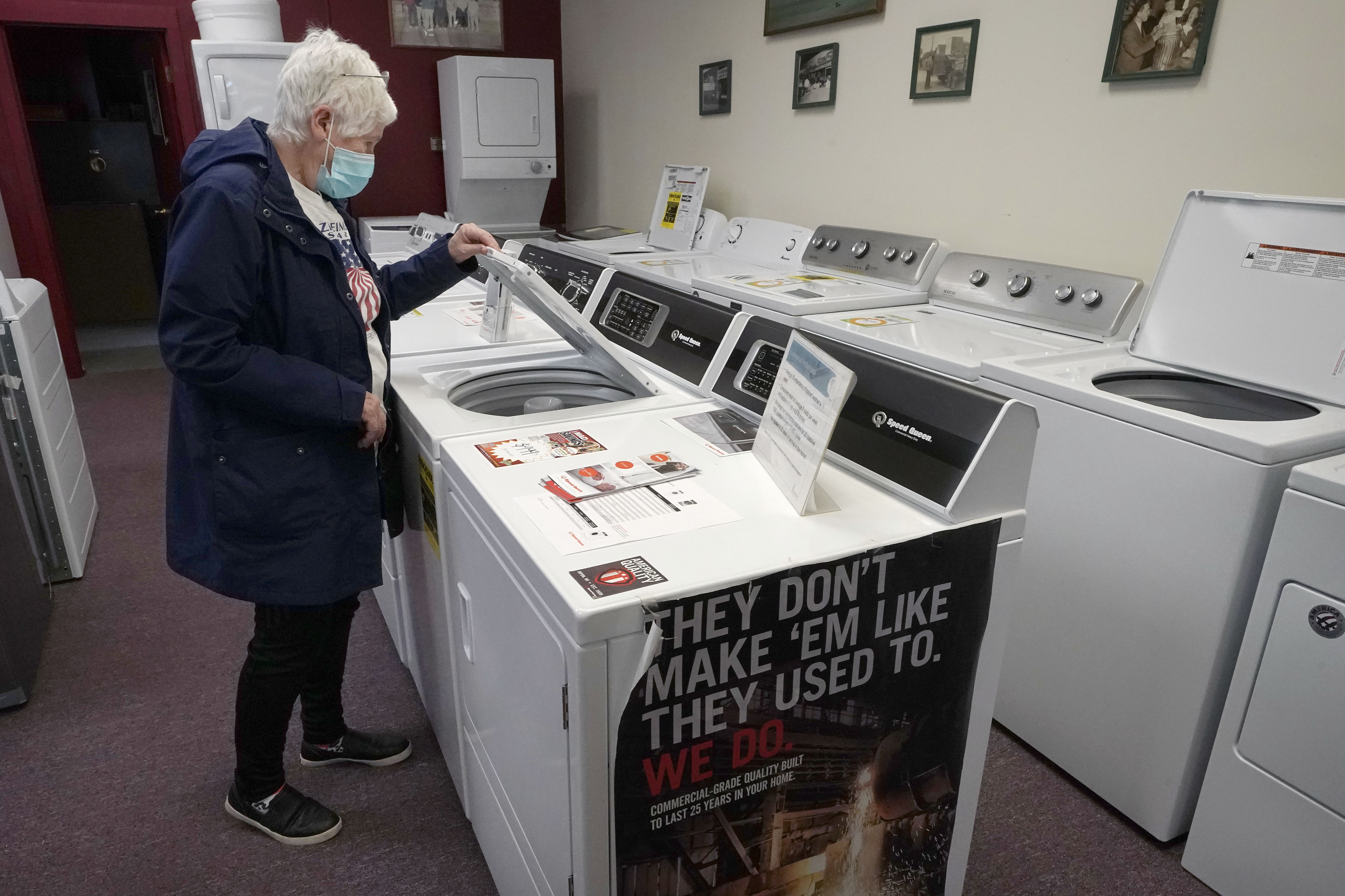 Alanna Kelly examines washers and dryers at Sam’s Appliances in Norwood, Massachusetts, in 2021. (Steven Senne/AP)