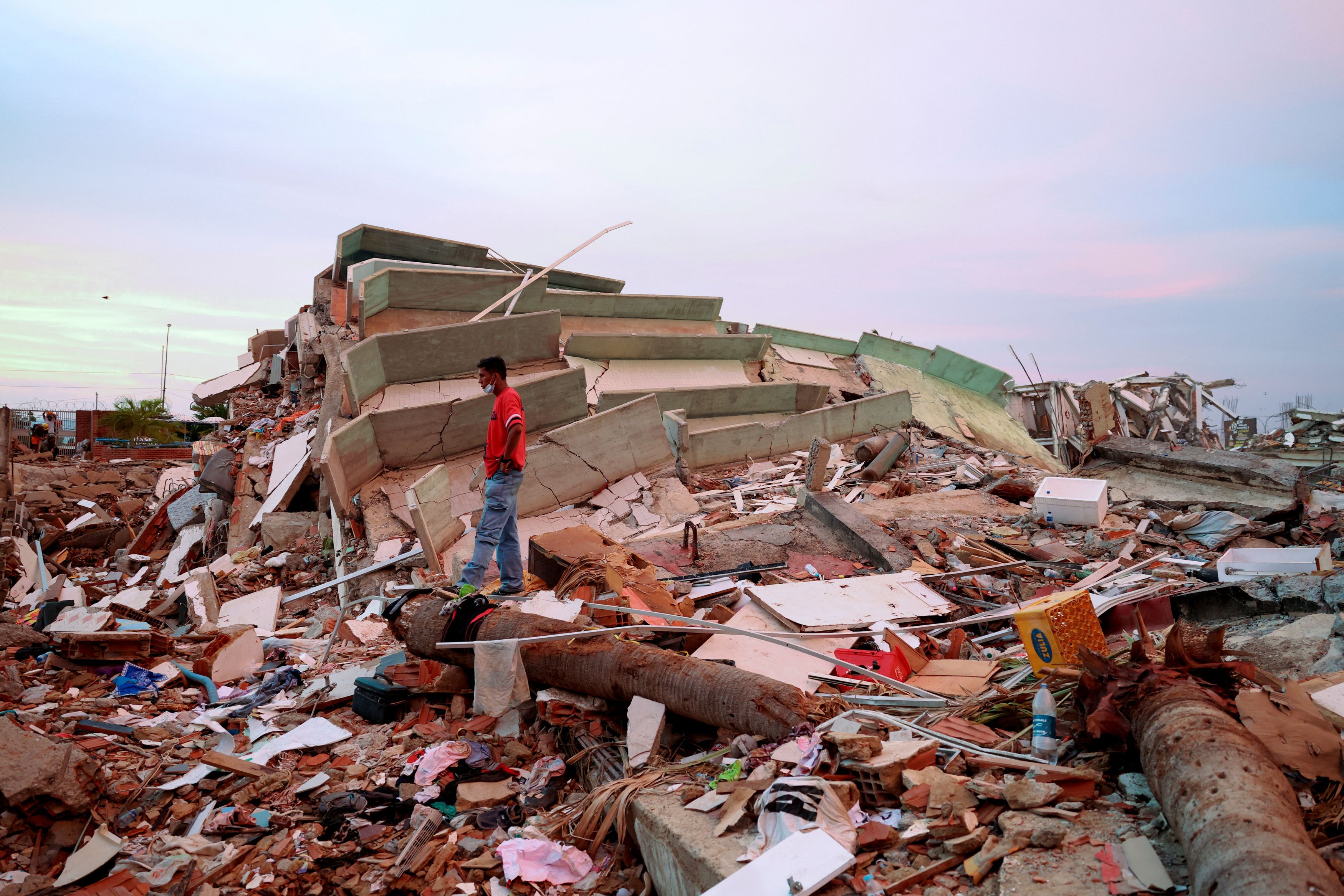 A man stands amid debris at the site of a collapsed building in the aftermath of earthquakes in La Guaira, Venezuela, on Tuesday. (Ricardo Arduengo/Reuters)