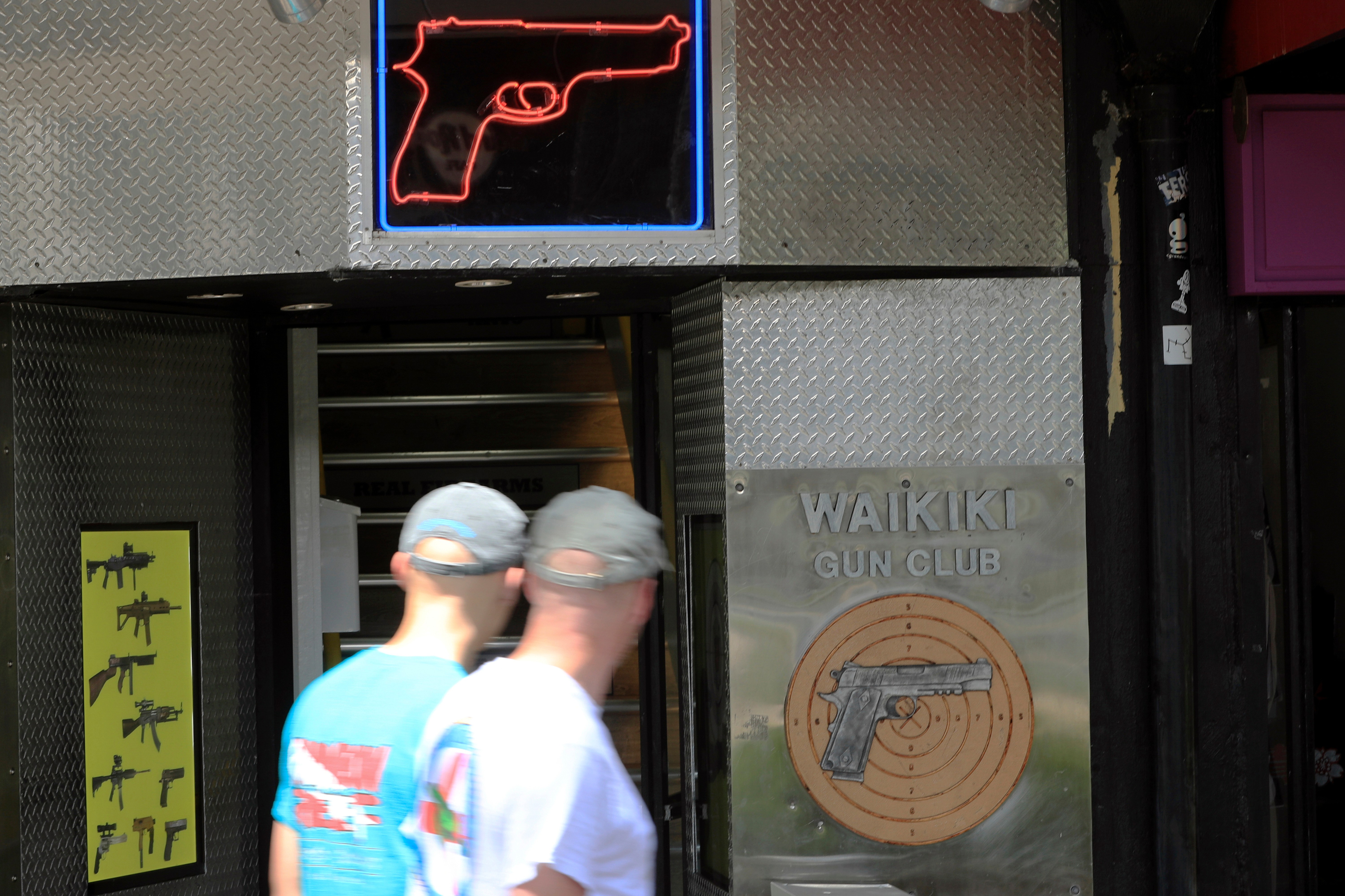 People walk past a gun club in Honolulu on June 23, 2022. (Marco Garcia/AP)