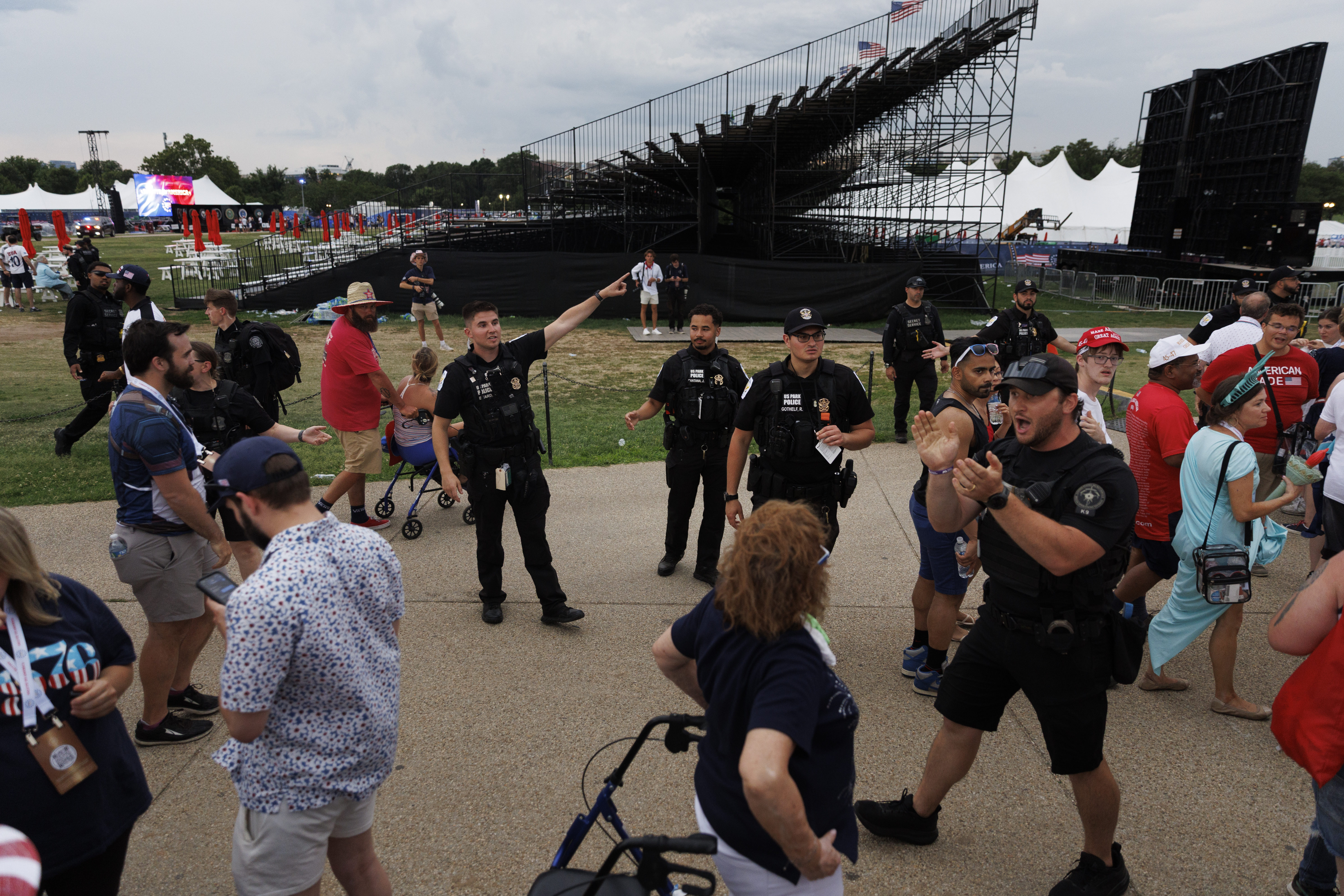 U.S. Park Police and Secret Service officers order people attending July Fourth celebrations on the National Mall to evacuate and seek shelter due to severe weather. (Tom Brenner/For The Washington Post)
