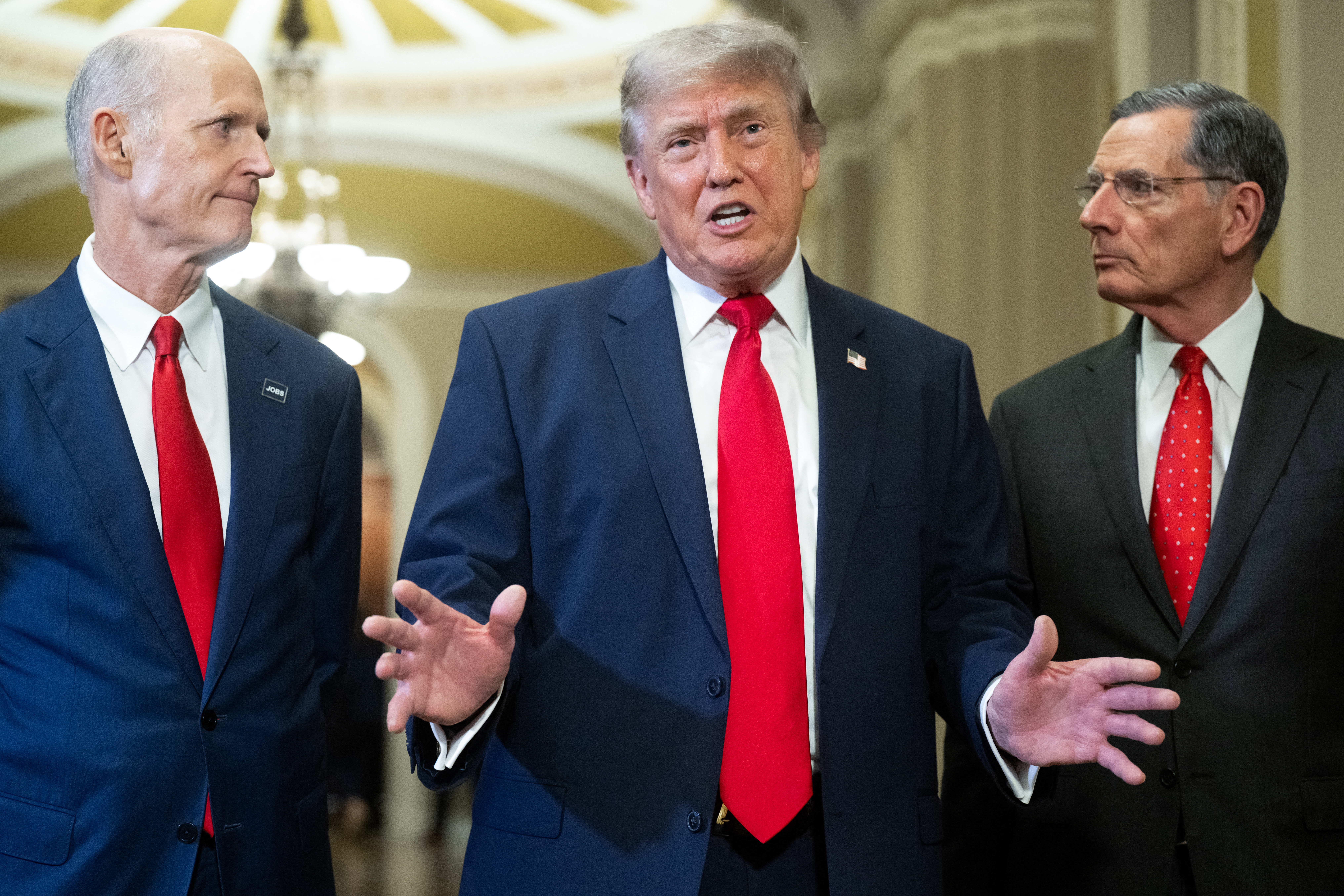 President Donald Trump, alongside Sens. Rick Scott (R-Florida), left, and John Barrasso (R-Wyoming), speaks to reporters on Wednesday at the Capitol. (Saul Loeb/AFP/Getty Images)