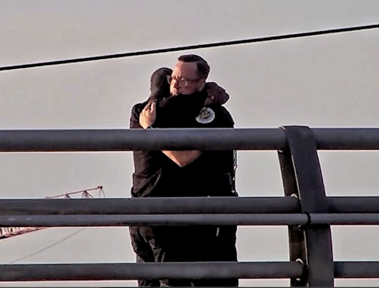 Lt. Mike Hotz of the Nashville police, as seen in a video still on the city’s Victory Memorial Bridge, hugs the man he helped on July 23. (Metropolitan Nashville Police Department)