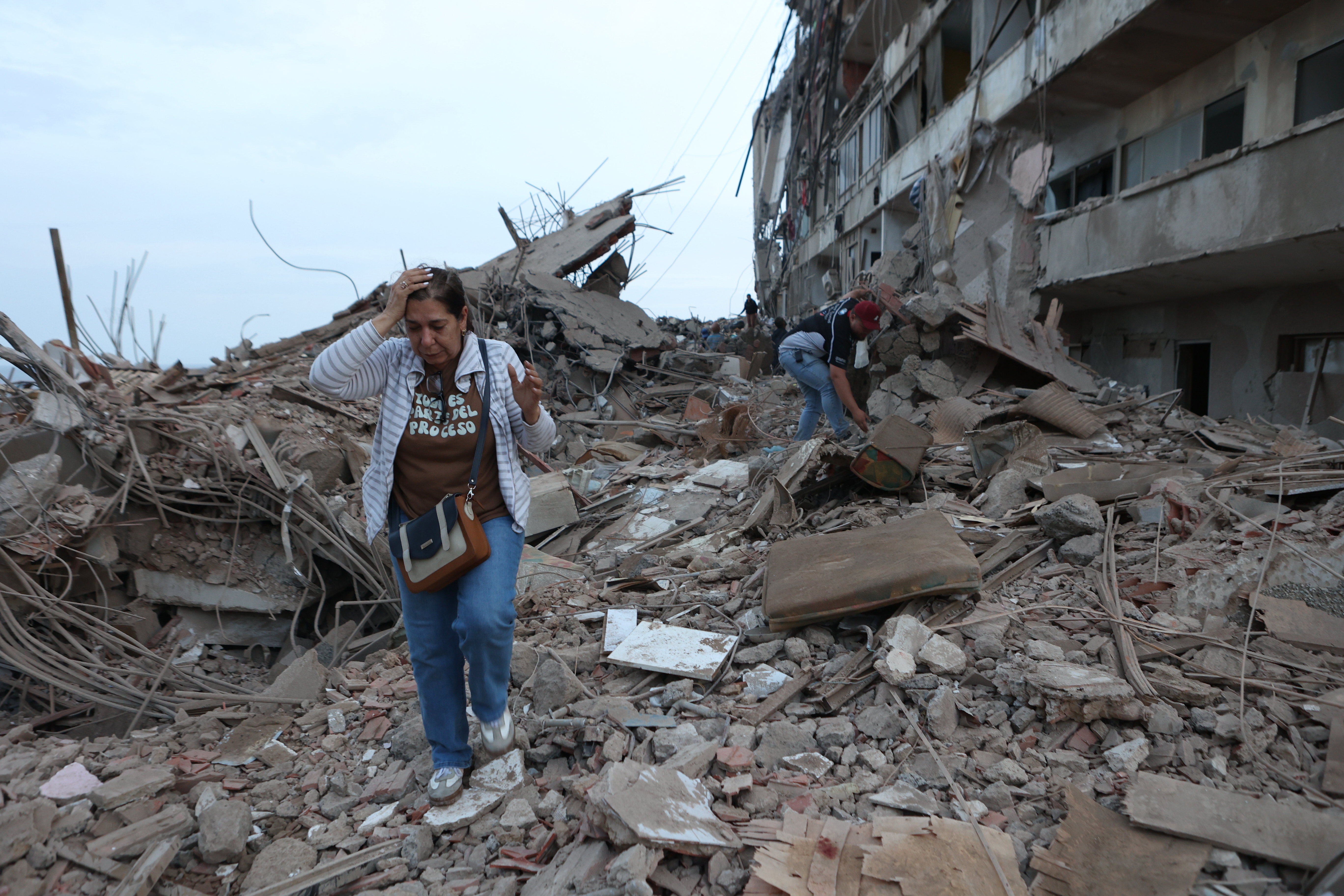 Residents walk among rubble Thursday after earthquakes hit the previous day in Catia La Mar, Venezuela. (Pedro Mattey/AP)