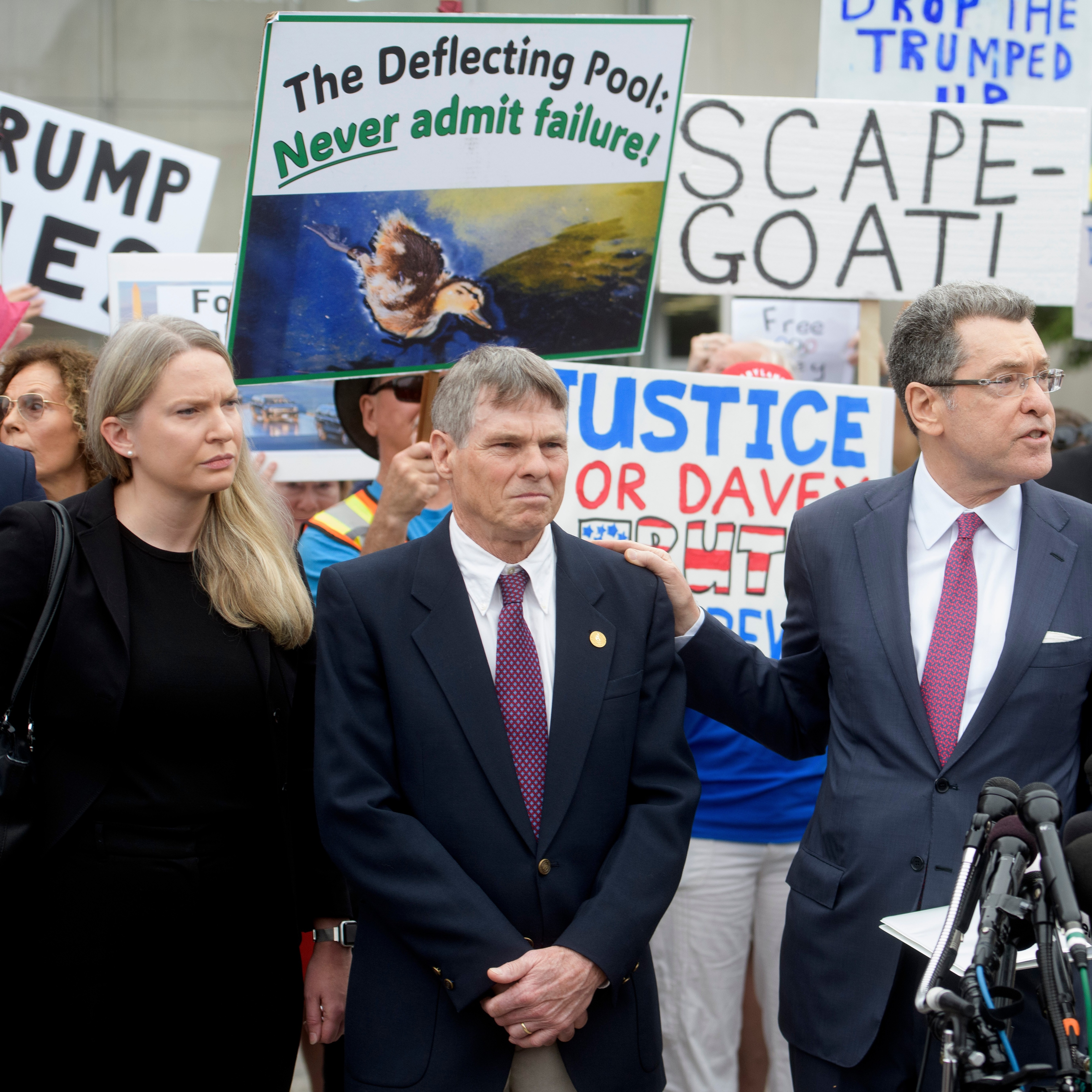 The Justice Department last week moved to drop the felony vandalism charge against David Hearn, center. (Rod Lamkey, Jr./AP)