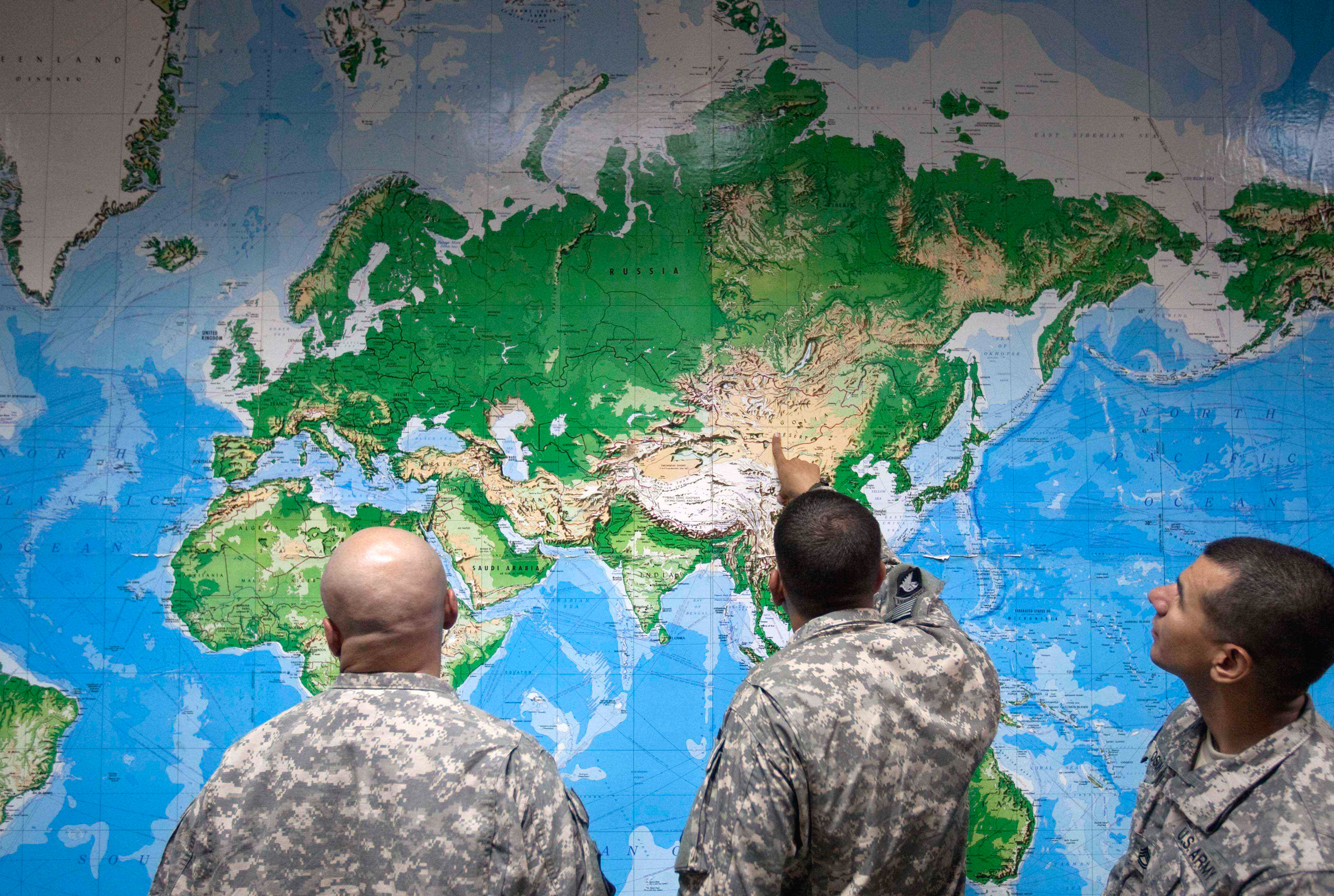 Soldiers look at a world map as they wait to board a flight in Manas, Kyrgyzstan, on the way home after completing a deployment in Afghanistan in 2011. (David Goldman/AP)