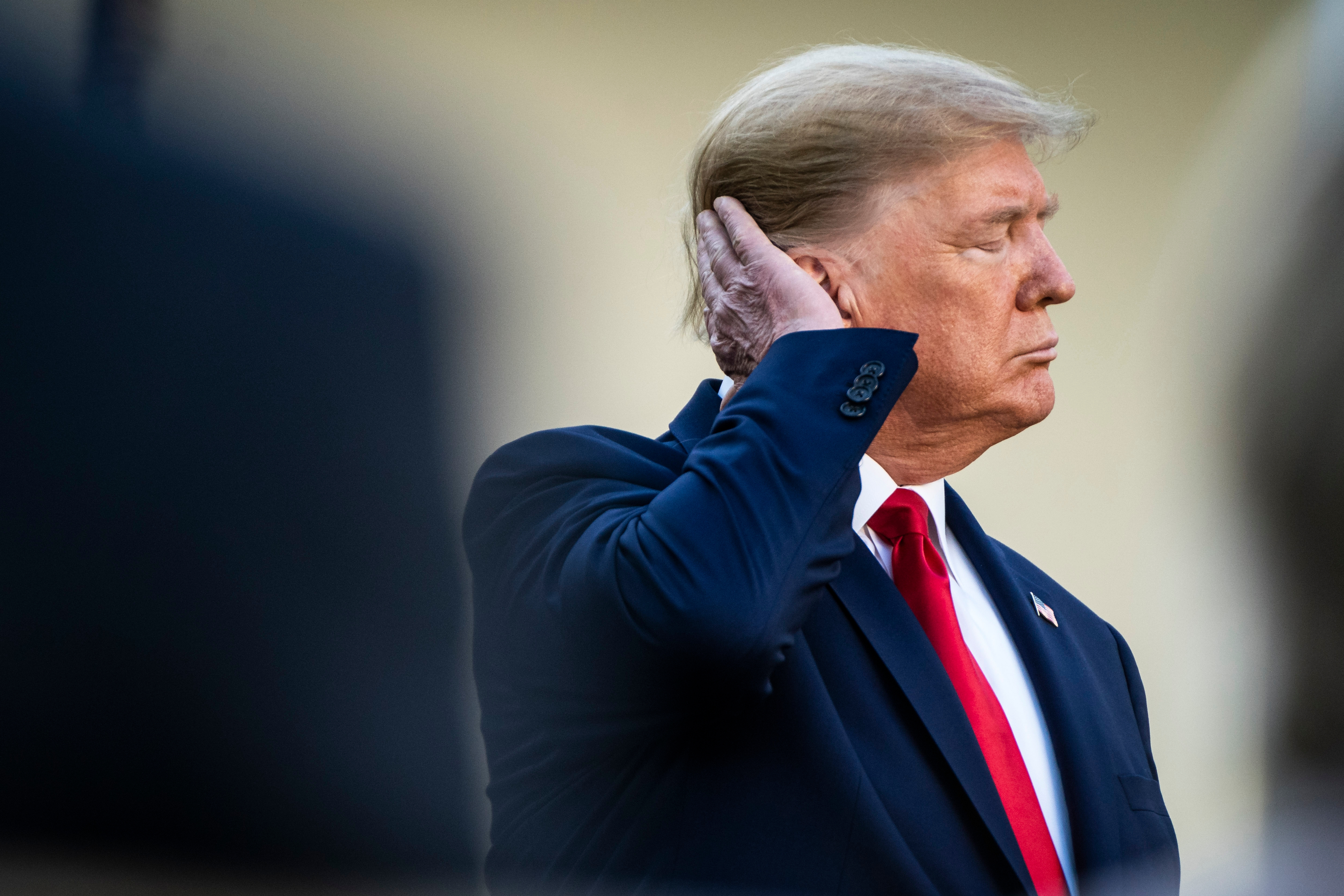President Donald Trump brushes his hair in the White House Rose Garden in 2020. (Jabin Botsford/The Washington Post)