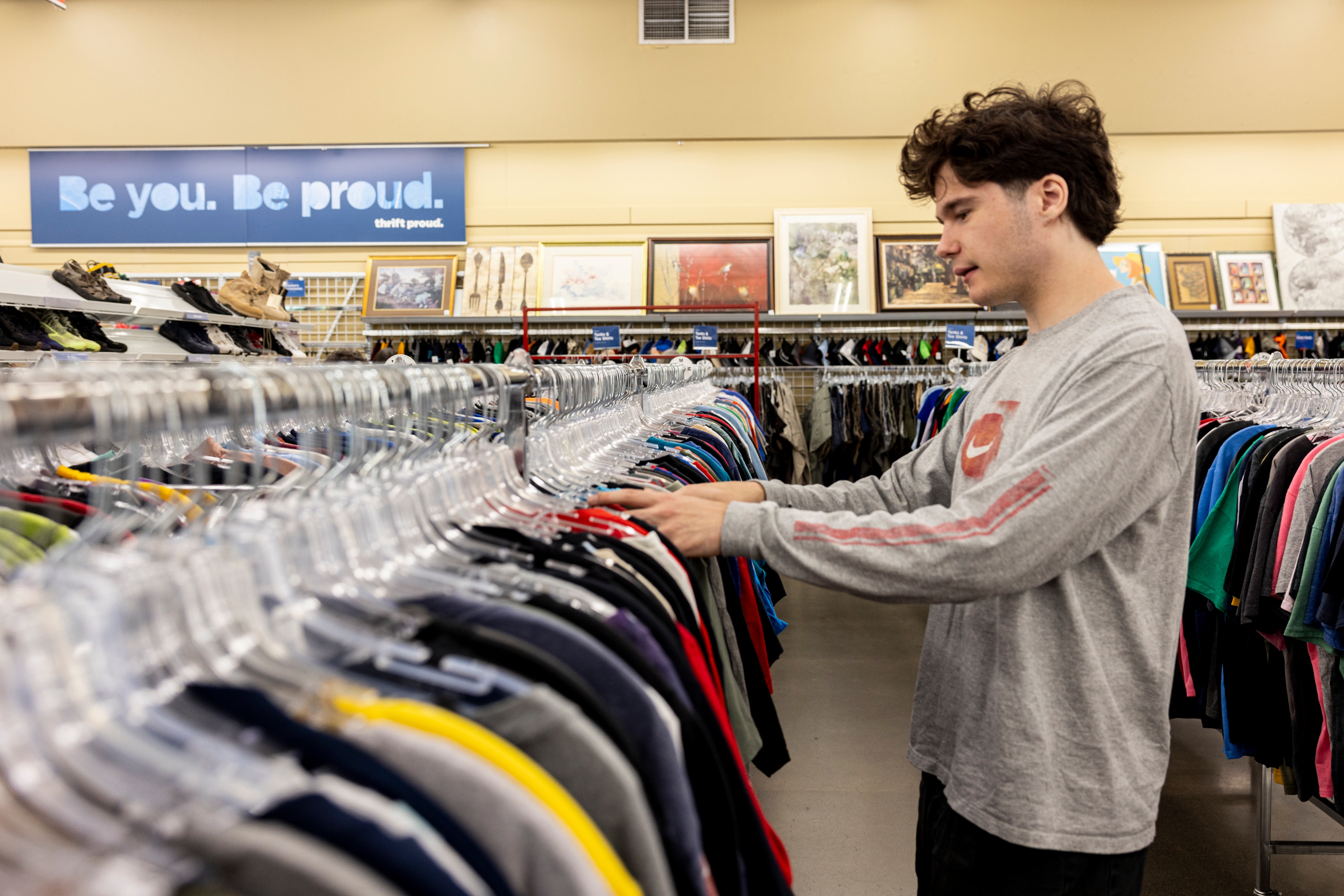 Quinn Brown looks through men’s shirts at Value Village in Tigard, Oregon, on July 14. (Celeste Noche for The Washington Post/© 2026 Celeste Noche for the Washington Post)