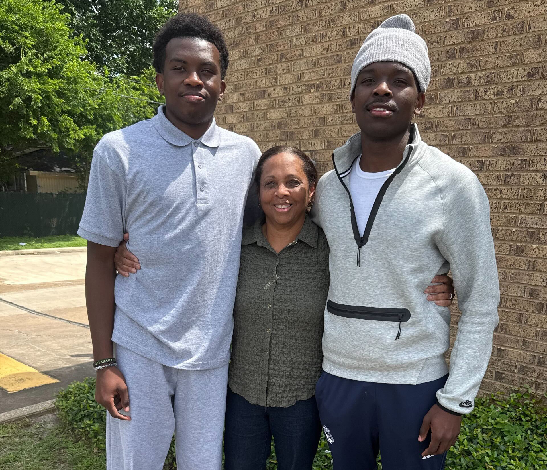Israel Makoka, 18, left, stands with his host mother, Gail Baptiste, and his brother, Max Makoka, 15. Both teens were released from federal immigration custody after being arrested for visa violations. (Family photo)