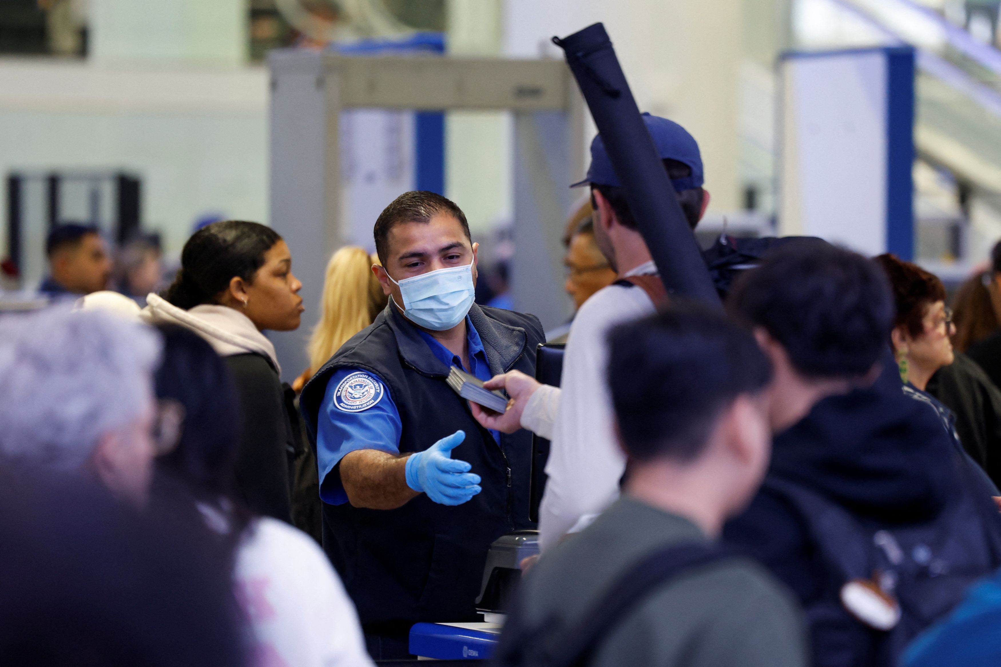A Transportation Security Administration agent and passengers at Los Angeles International Airport on Monday. (Caroline Brehman/Reuters)