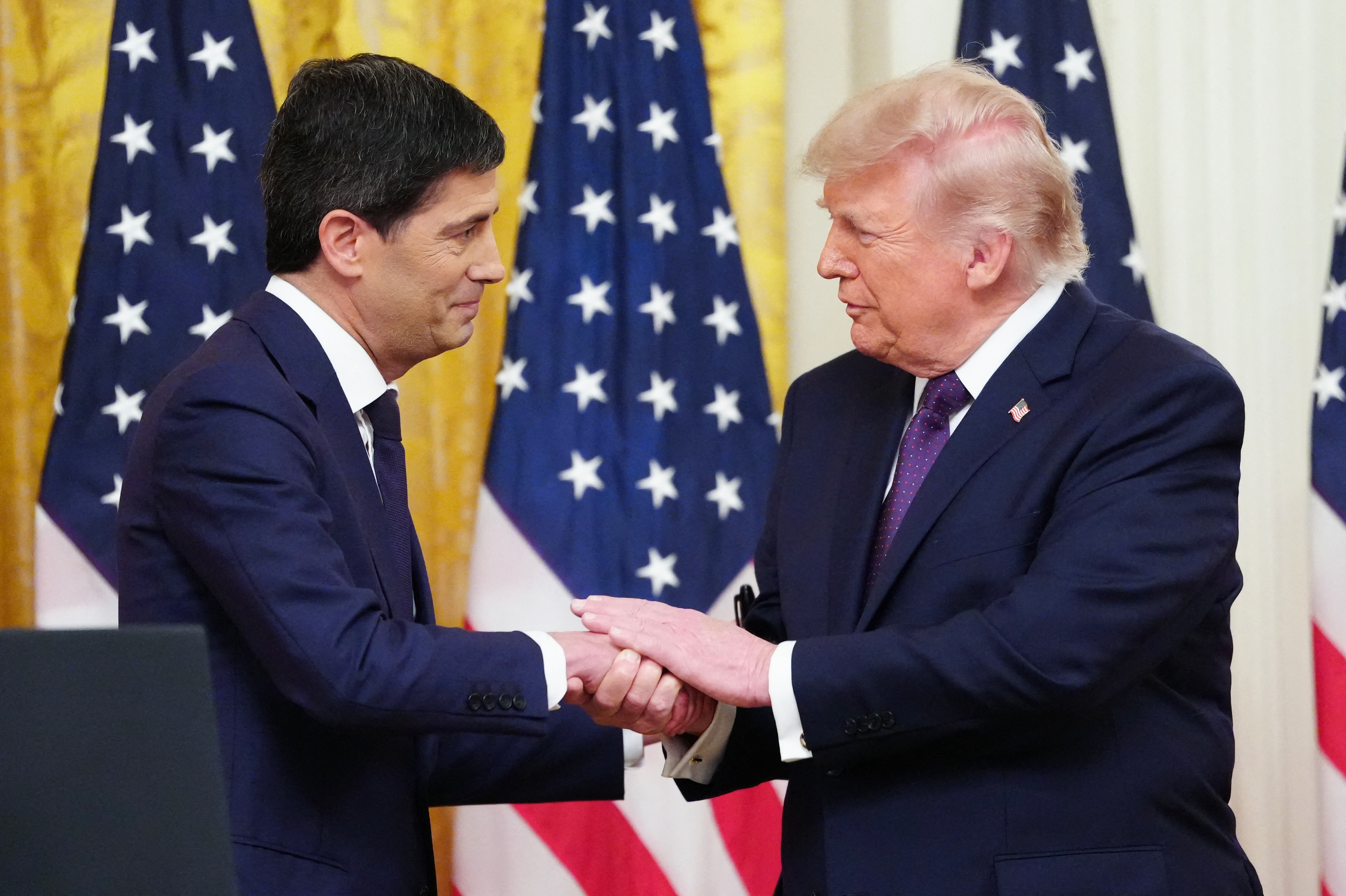 Federal Reserve Chair Kevin Warsh and President Donald Trump, seen in May, share a conviction that AI can deliver an economic revolution. (Aaron Schwartz/AFP/Getty Images)