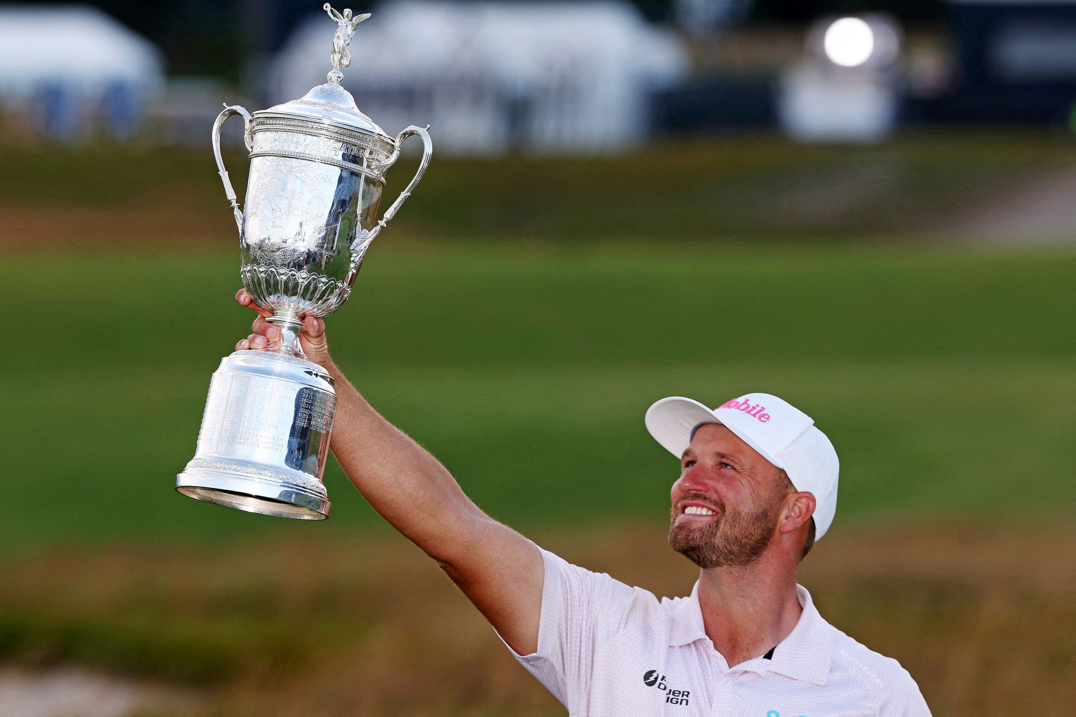 Wyndham Clark hoists the U.S. Open trophy for the second time in four years after holding off Sam Burns by a stroke. (Bill Streicher/IMAGN IMAGES via Reuters Connect)