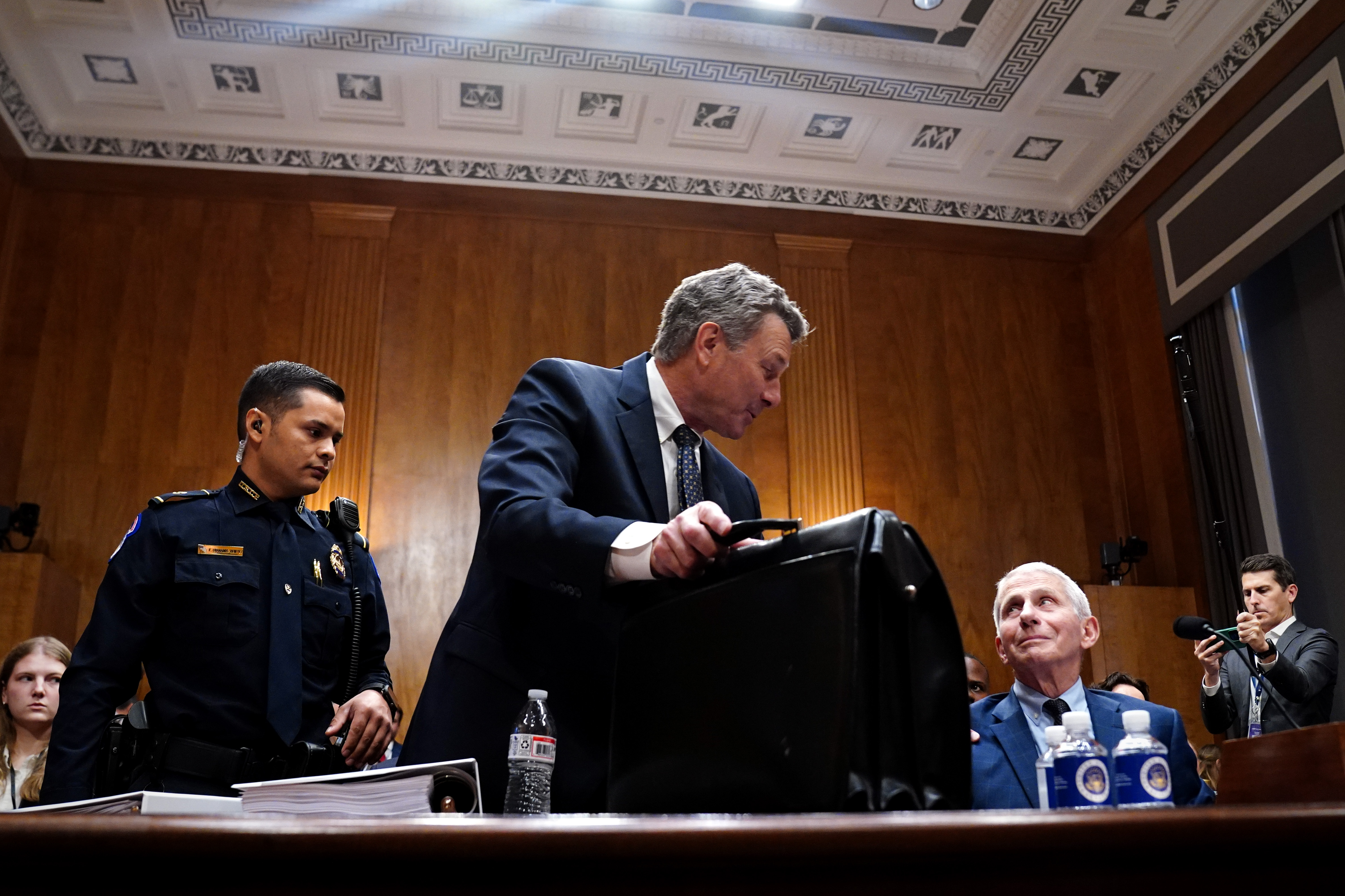 David Schertler, center, an attorney for infectious-disease expert Anthony S. Fauci, right, is removed by Capitol Police from a Senate hearing Wednesday at the Capitol. (Maxine Wallace/The Washington Post)