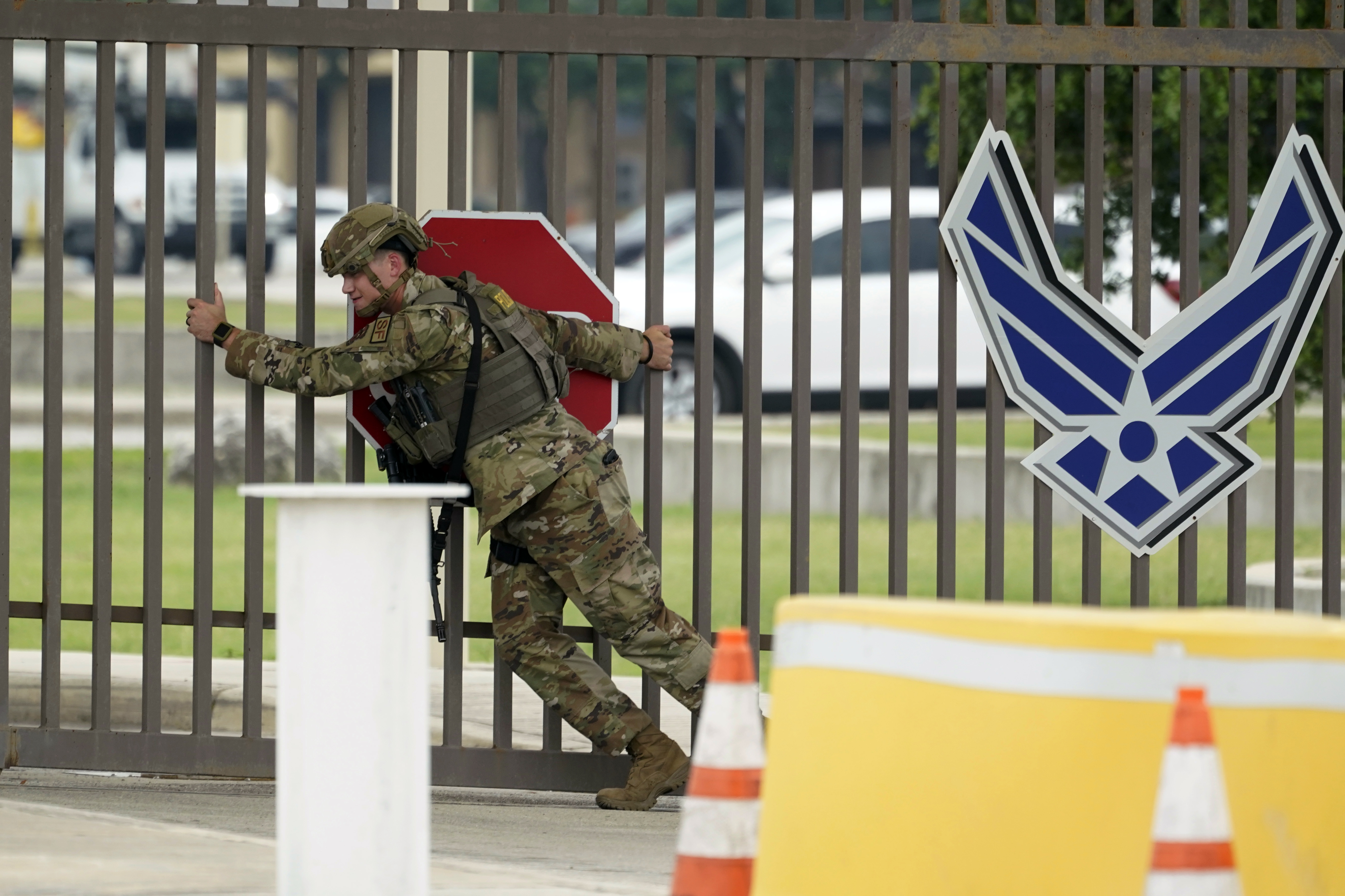 A military officer closes a gate at Lackland Air Force Base in Texas. (Eric Gay/AP)