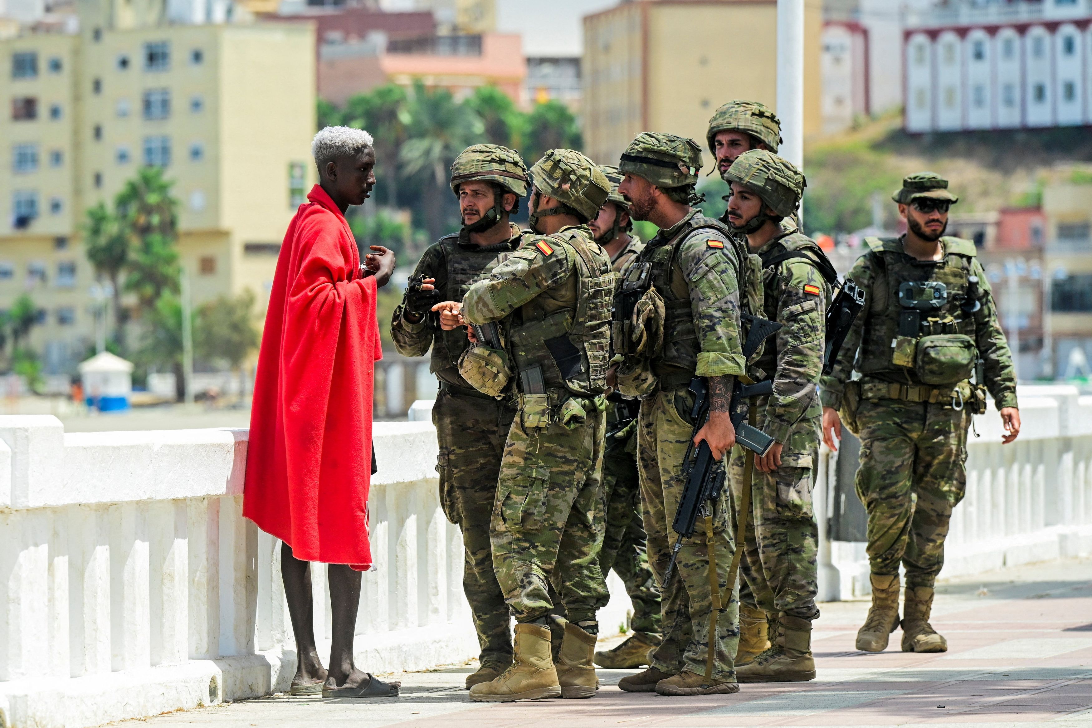 Spanish soldiers question a migrant Saturday in Ceuta, a Spanish territory in North Africa. (Fabian Bimmer/Reuters)