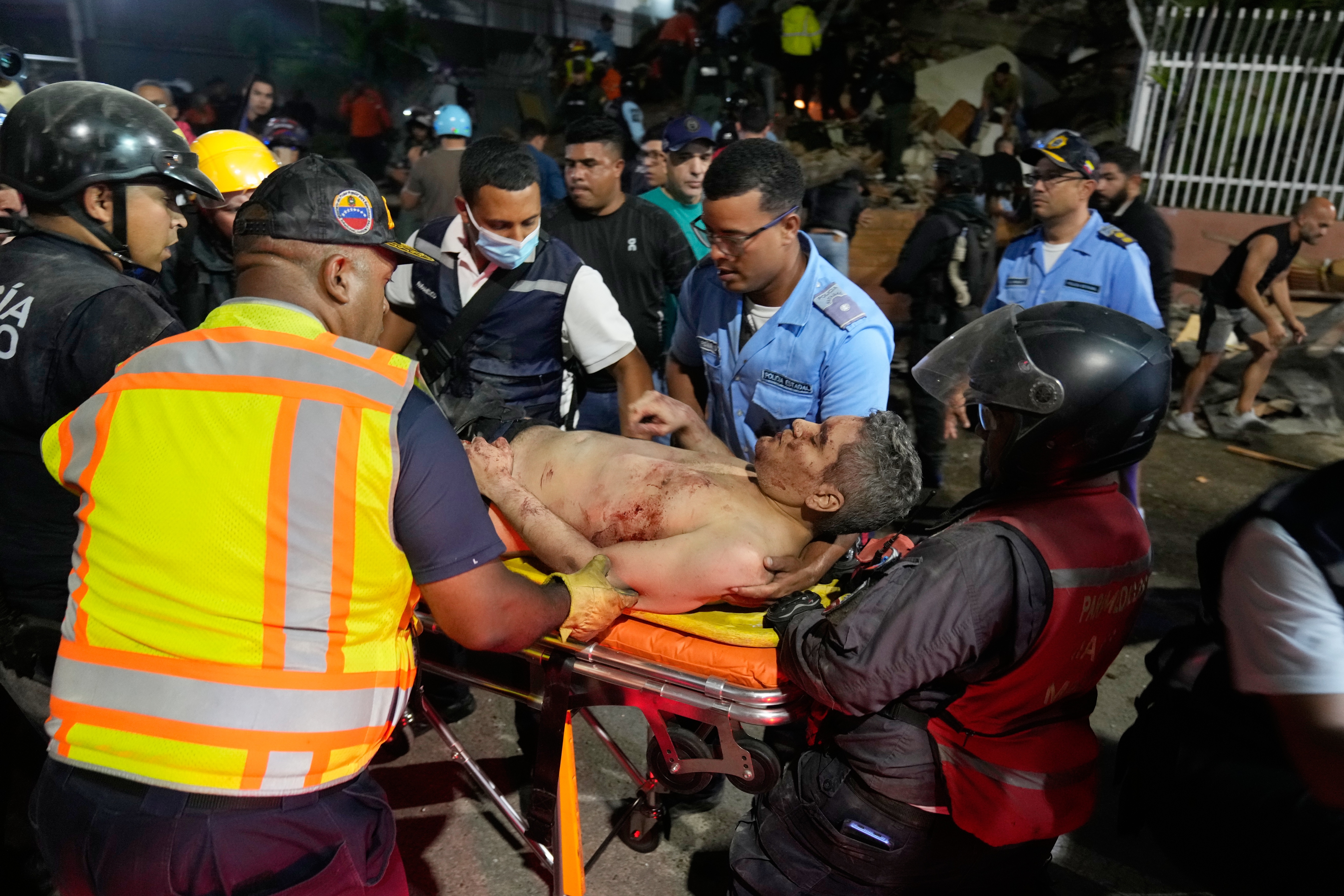 Rescue workers carry an injured man after an earthquake in Caracas, Venezuela, on Wednesday. (Ariana Cubillos/Ap Photo/Ariana Cubillos)
