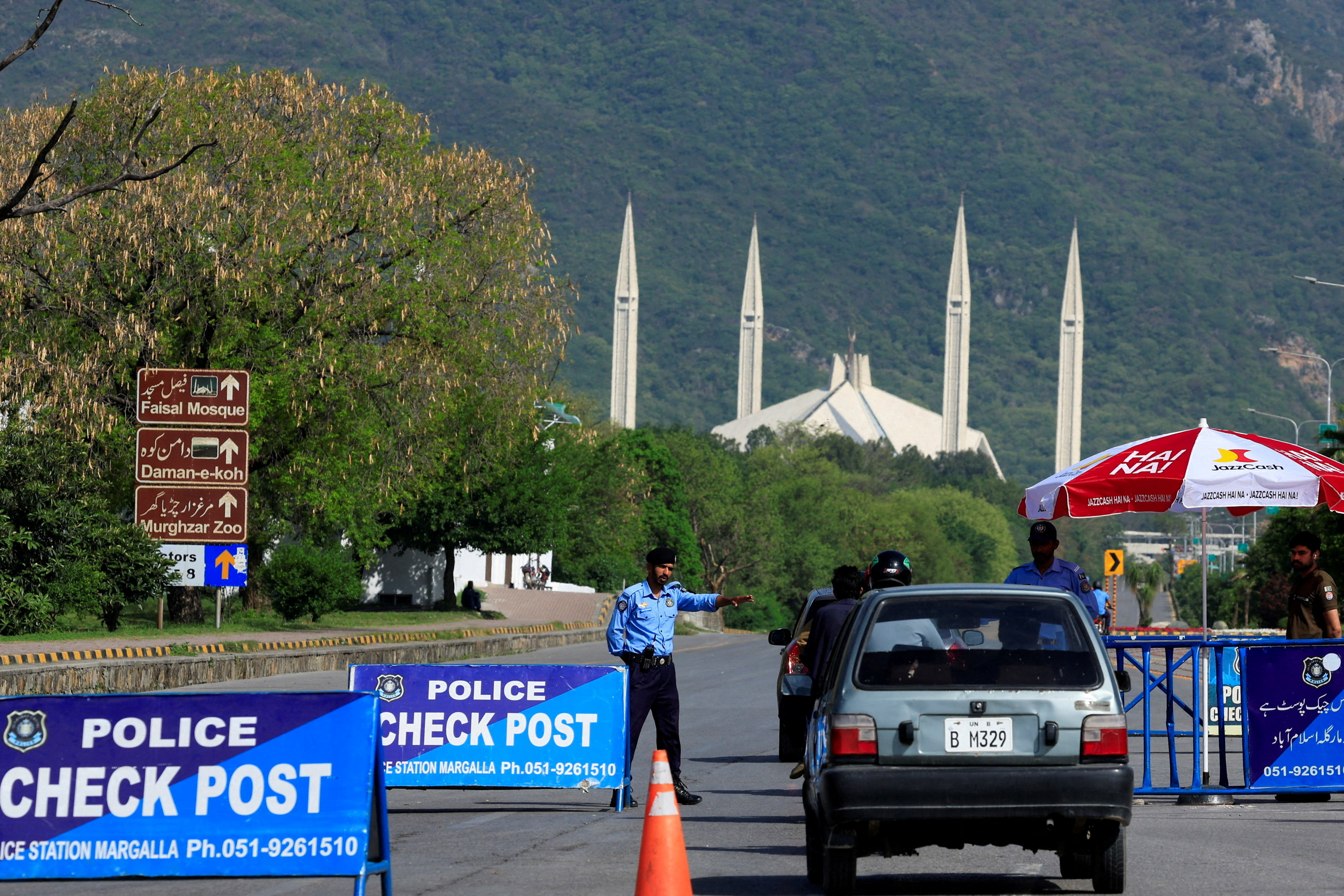A police officer gestures to a vehicle Sunday at a checkpoint in Islamabad. Plans were underway in the Pakistani capital for a new round of U.S.-Iran talks. (Akhtar Soomro/Reuters)