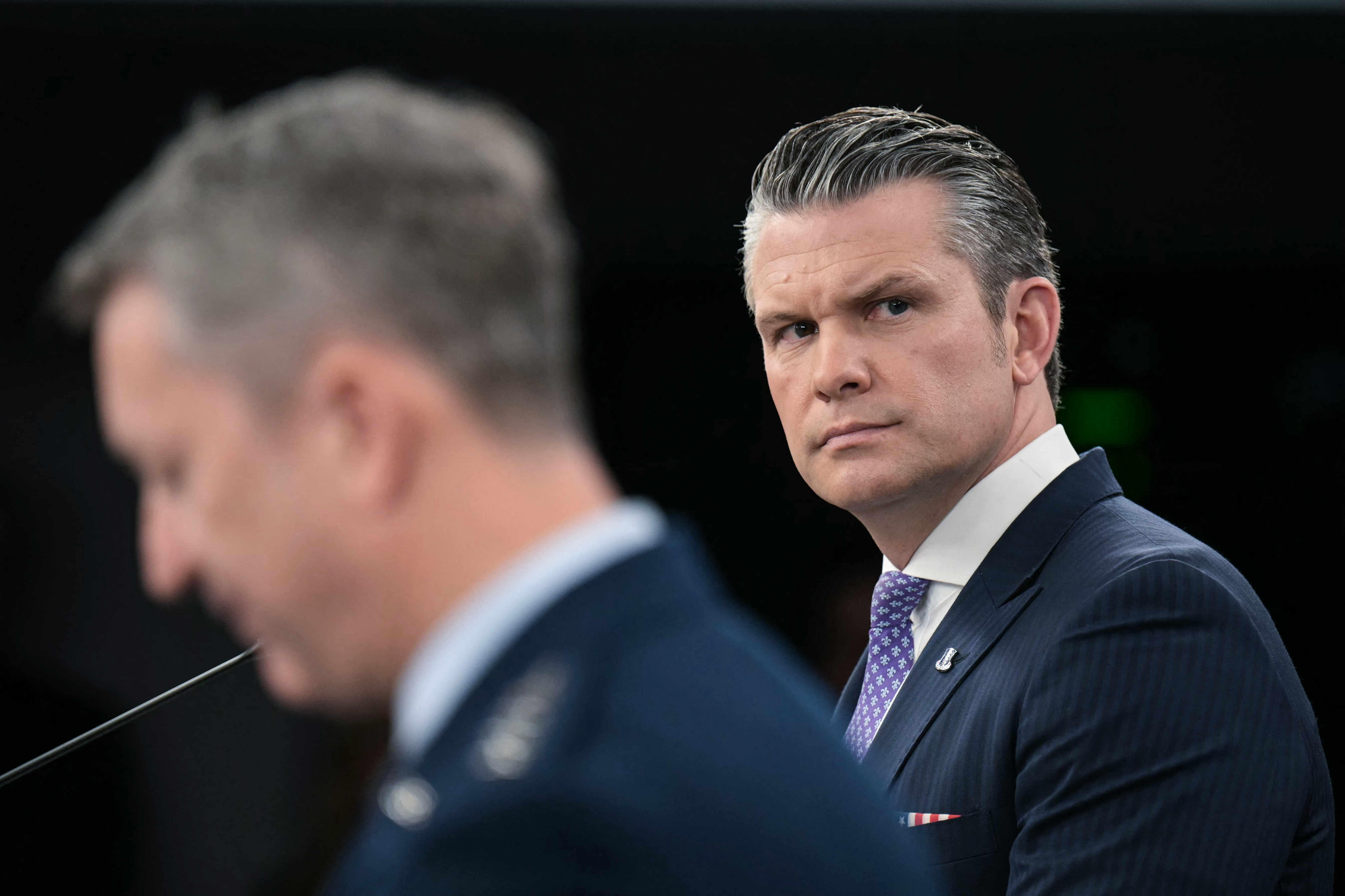Defense Secretary Pete Hegseth speaks to the news media alongside Gen. Dan Caine, chairman of the Joint Chiefs of Staff, at the Pentagon on Tuesday. (Oliver Contreras/AFP/Getty Images)