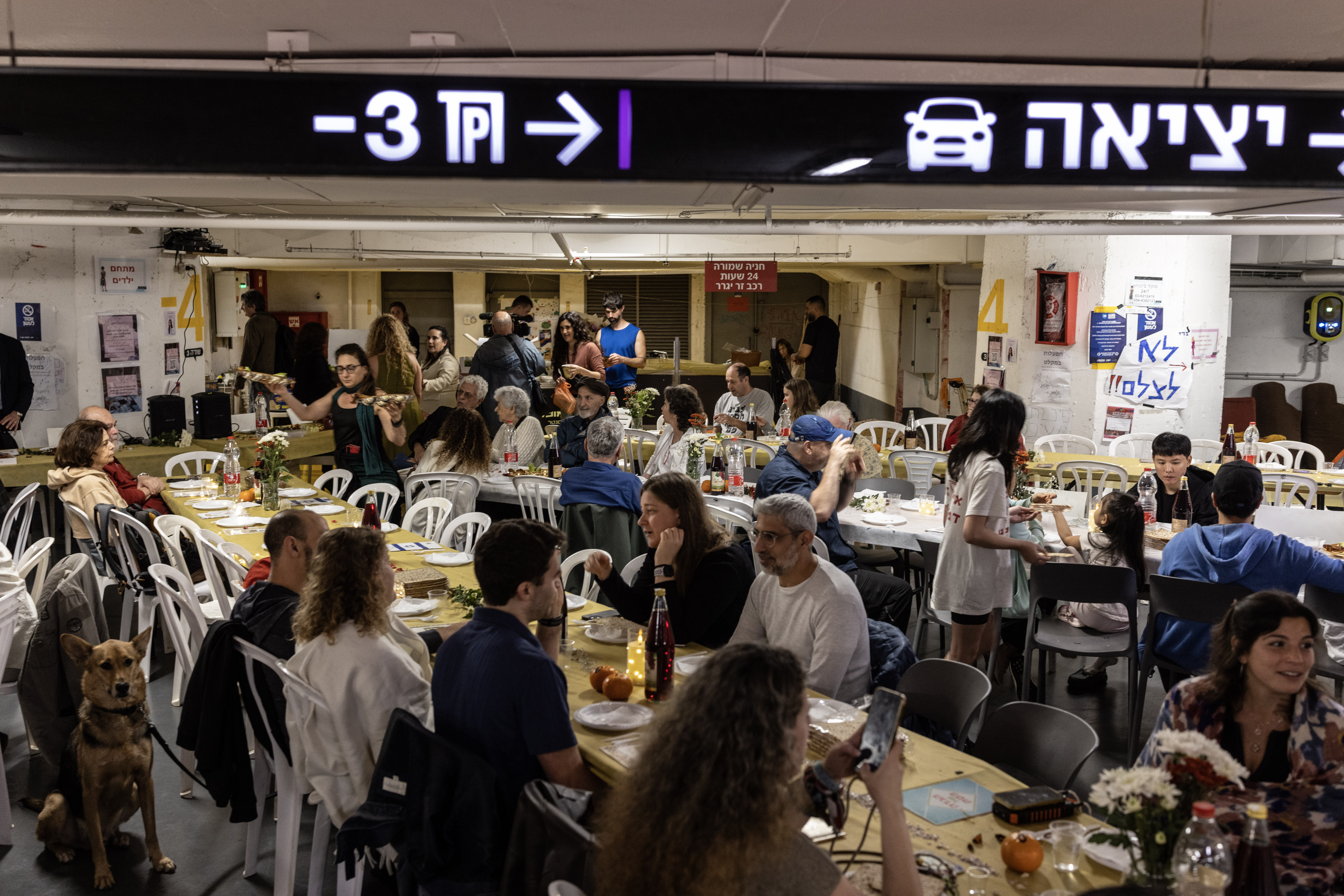 People gather for a communal Passover seder in an underground parking lot that serves as a bomb shelter in Tel Aviv on Wednesday. (Photos by Heidi Levine/For The Washington Post)