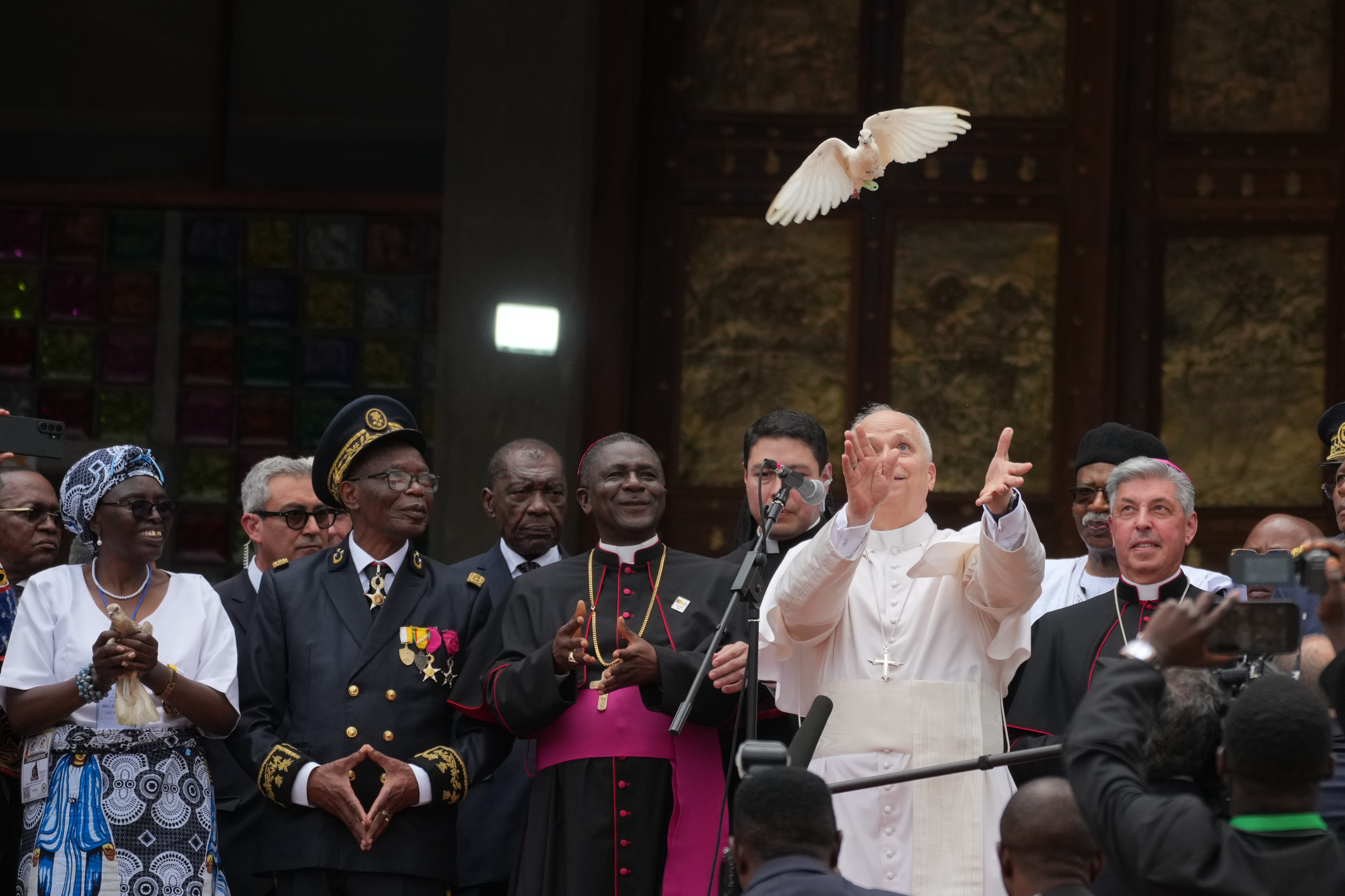 Pope Leo XIV, with the archbishop of Bamenda, Cameroon, Andrew Nkea Fuanya, left, frees a white dove at the end of a meeting for peace this month during his tour through Africa. (Andrew Medichini/AP)