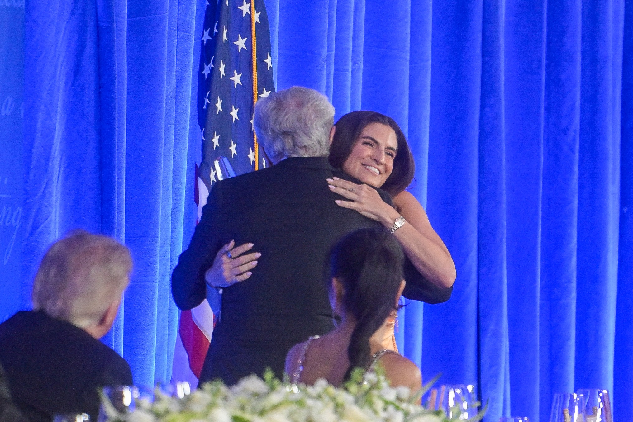 President Donald Trump, left, looks on as Wolf Blitzer embraces fellow CNN correspondent Kaitlan Collins at the White House Correspondents' Association Dinner on Friday night in Washington. (Rod Lamkey/AP)